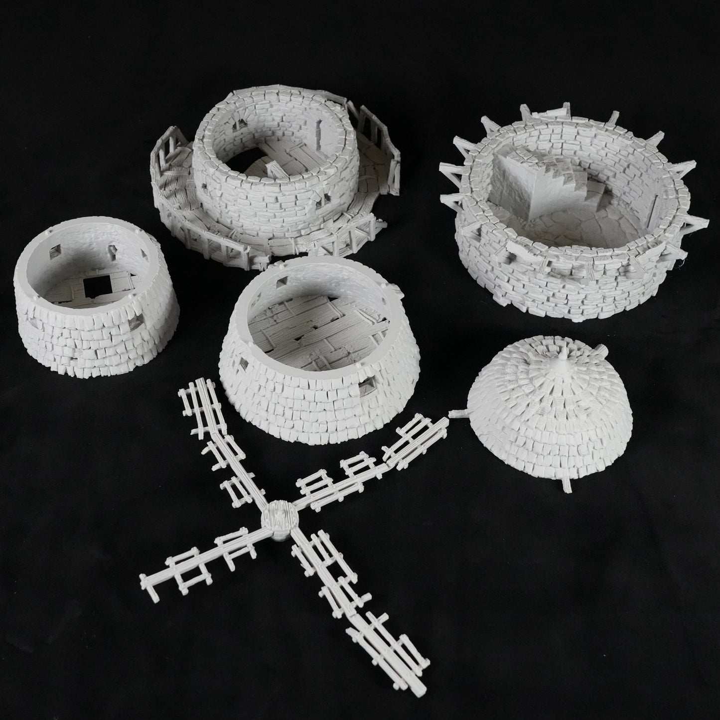 Weiße, detaillierte Miniaturmodelle einer verfluchten Windmühle mit Turm, Windmühlenflügeln und Rundmauerwerk.
