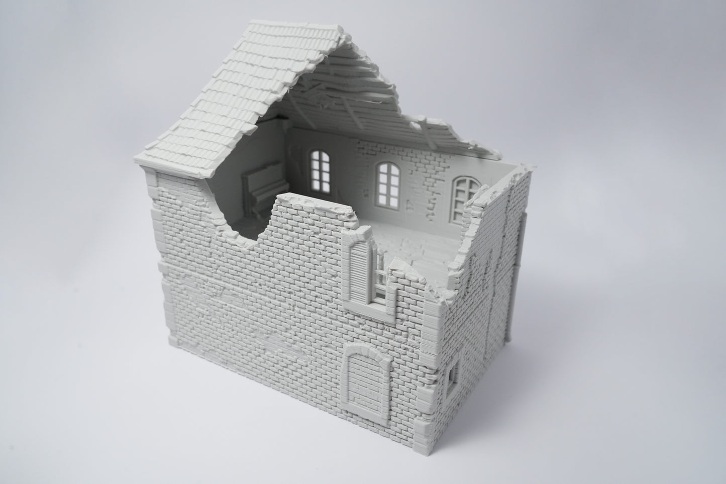 Unbemaltes 3D-Modell einer halb zerstörten französischen Hausruine aus Mauerwerk in Grau.