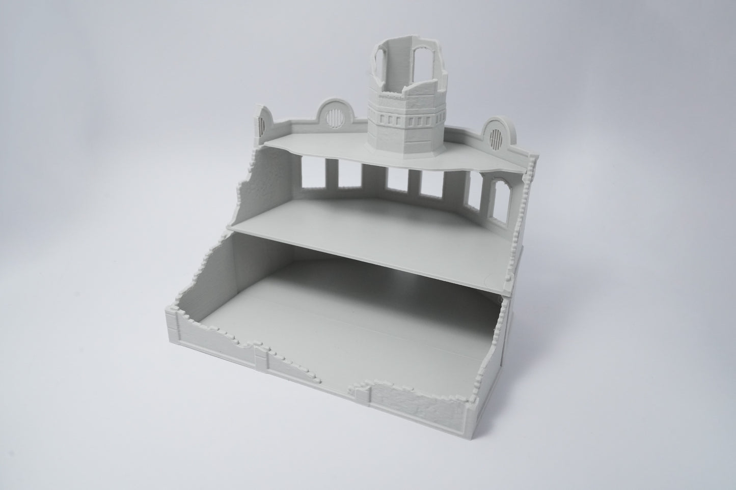Graues, unbemaltes Modell einer zerfallenen Fabrikruine mit zerstörtem Dach und erhabenen Details.