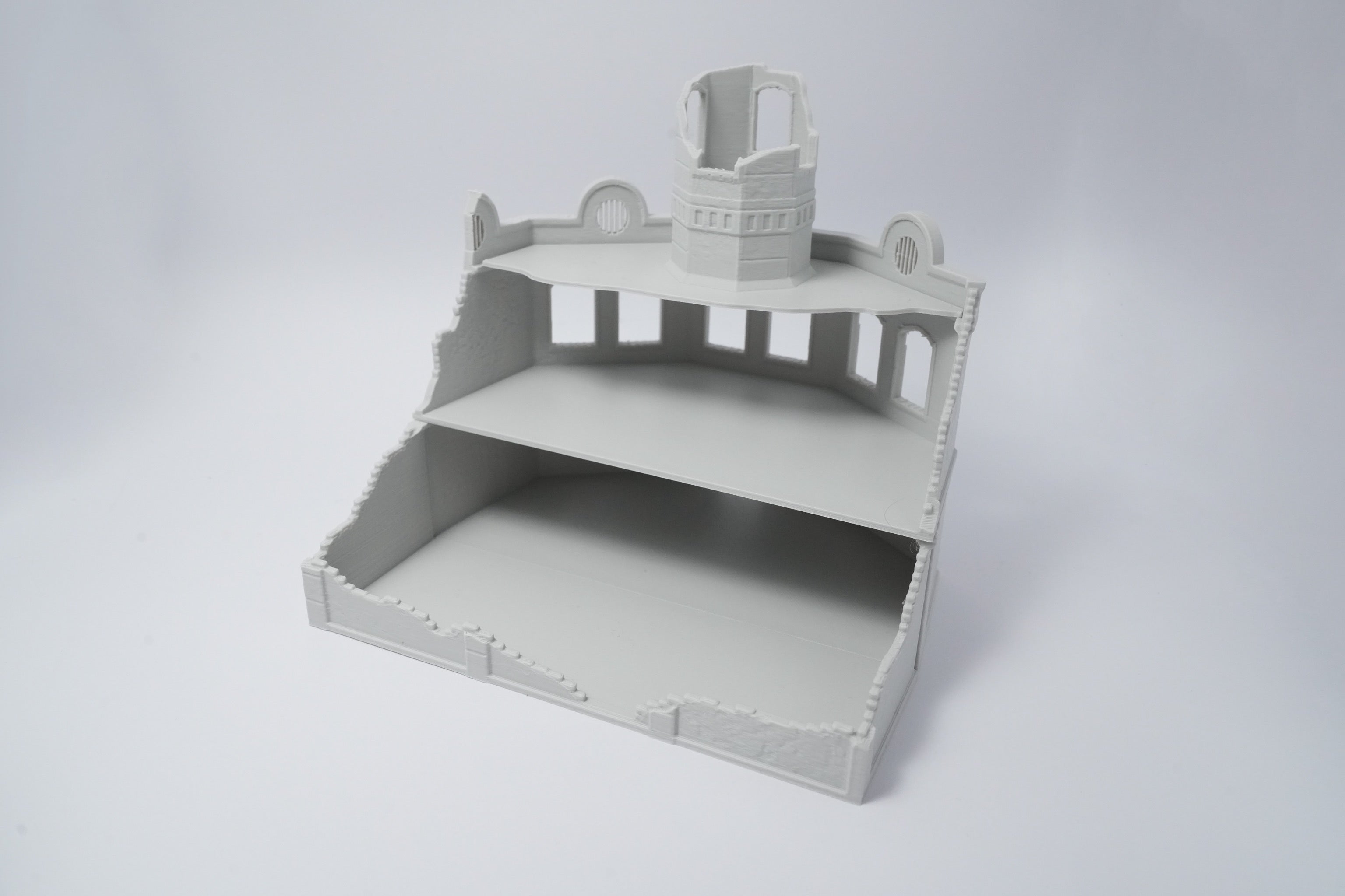 Graues, unbemaltes Modell einer zerfallenen Fabrikruine mit zerstörtem Dach und erhabenen Details.