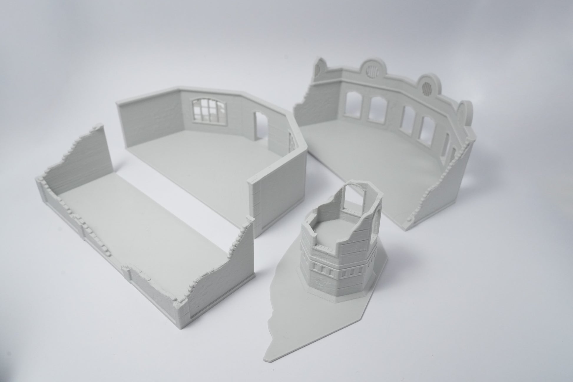 Graue Resin-Modelle von sowjetischen Fabrikruinen mit beschädigten Wänden und Fensteröffnungen.