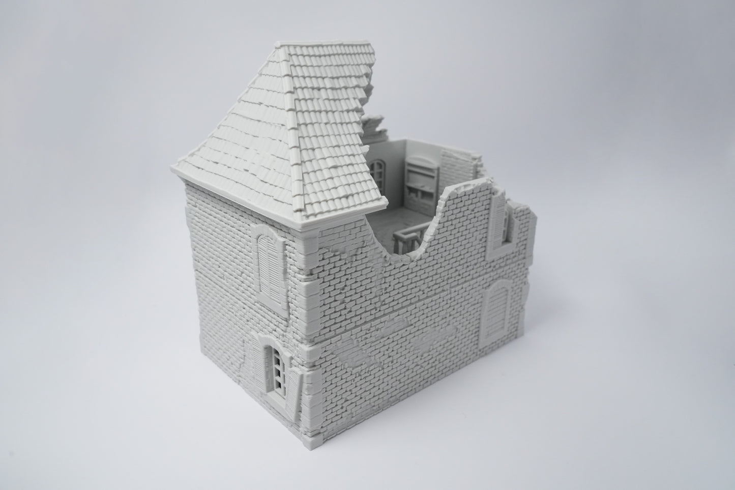 Graues, detailliertes Modell einer zerfallenen französischen Hausruine mit beschädigtem Dach und beschädigten Wänden.