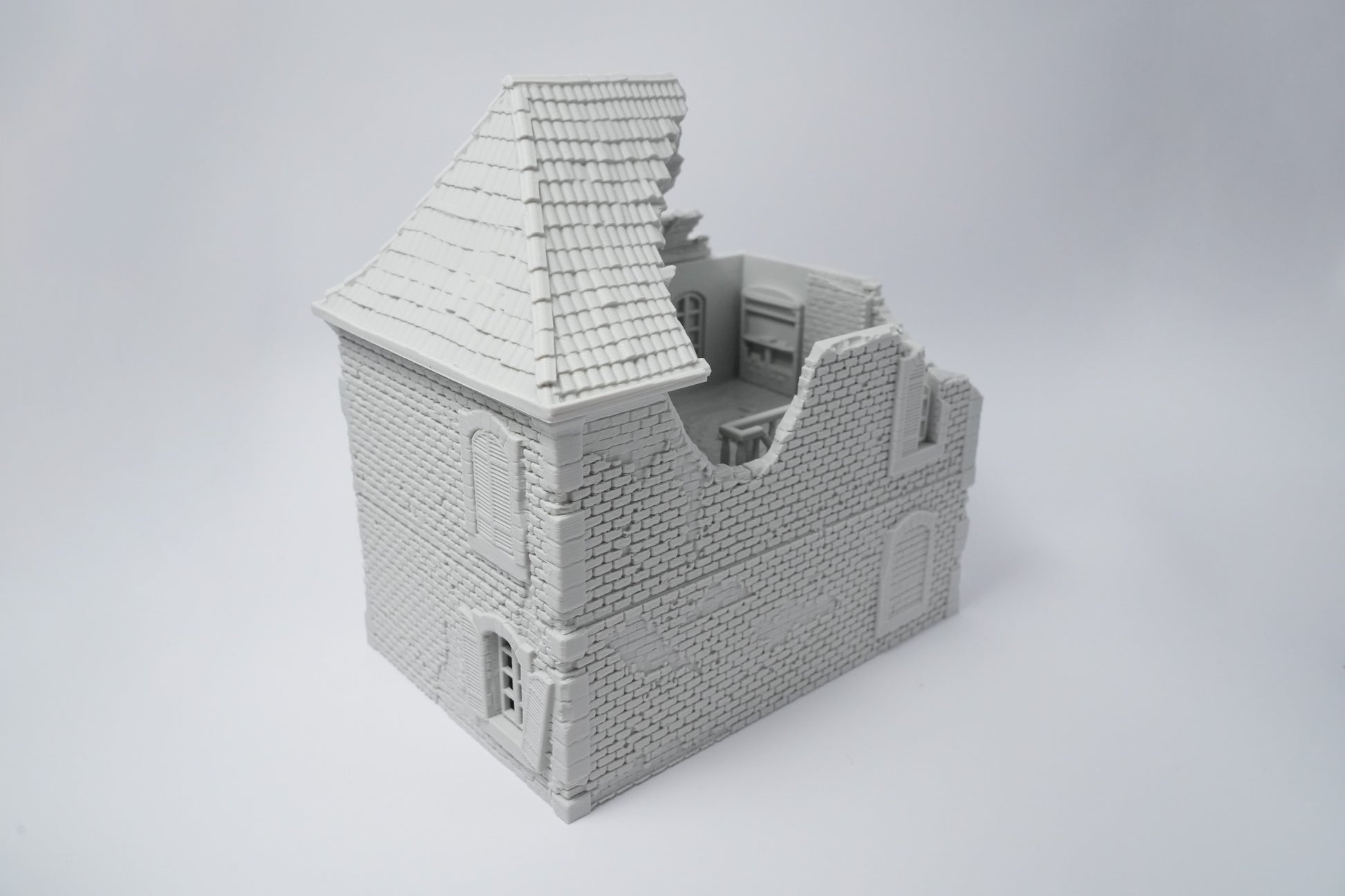 Graues, detailliertes Modell einer zerfallenen französischen Hausruine mit beschädigtem Dach und beschädigten Wänden.