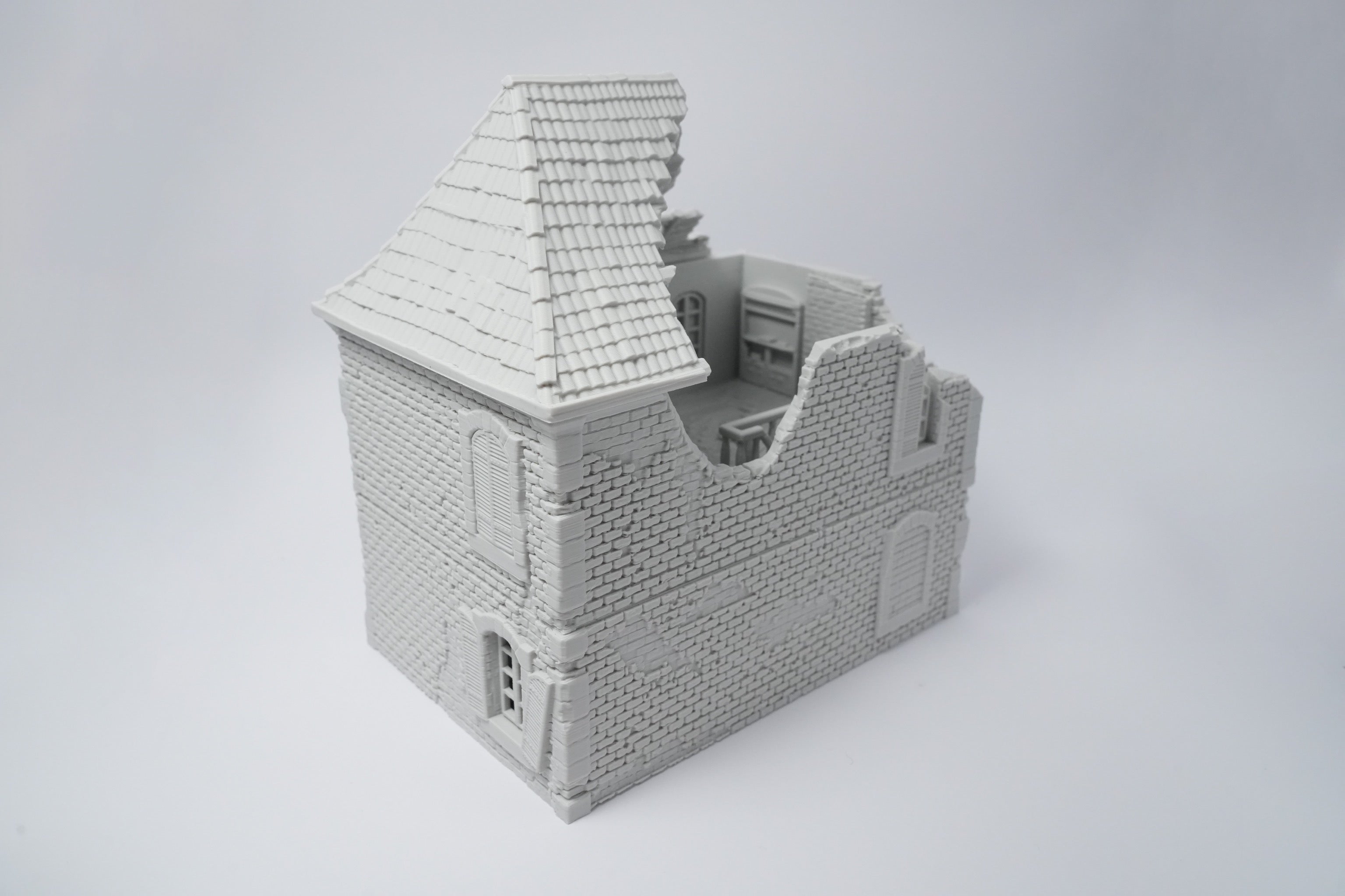 Graues, detailliertes Modell einer zerfallenen französischen Hausruine mit beschädigtem Dach und beschädigten Wänden.