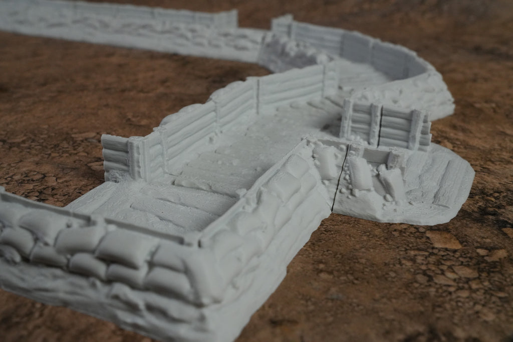 Grauer Schützengraben mit Sandsäcken und Bretterverkleidung auf braunem Boden, Modellbau-Detail.