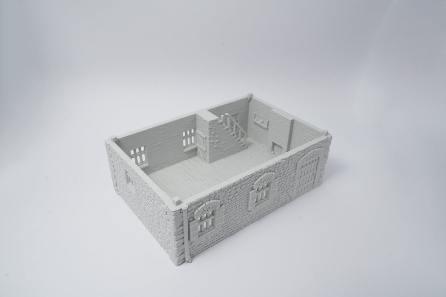 Graues Miniaturmodell eines französischen Farmhauses mit detailreichen Fenstern und Türen.