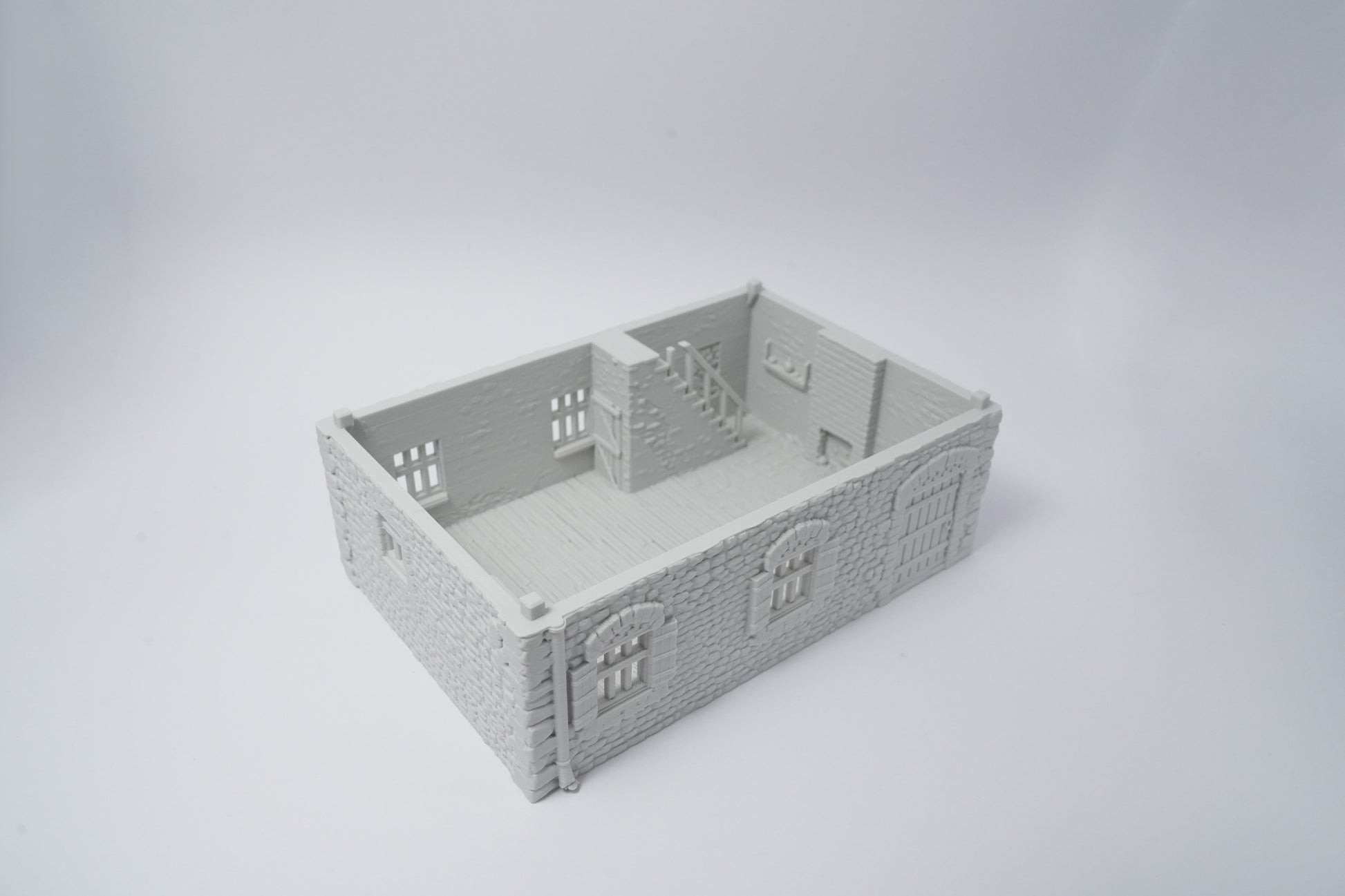 Graues Miniaturmodell eines französischen Farmhauses mit detailreichen Fenstern und Türen.
