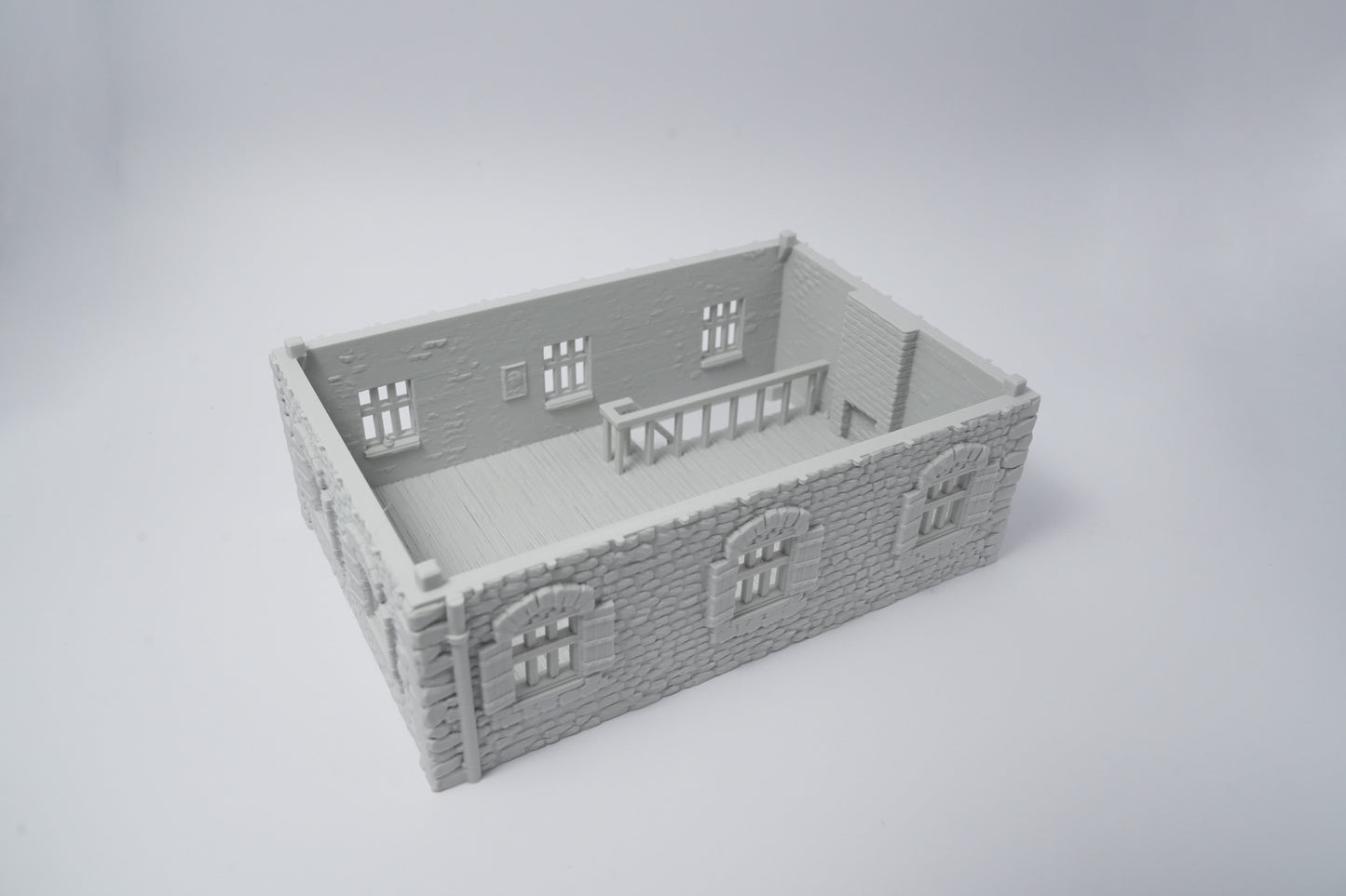 Graues Miniatur-Farmhaus aus Kunststoff mit detaillierten Fenstern und Backsteinmauern, rechteckig.
