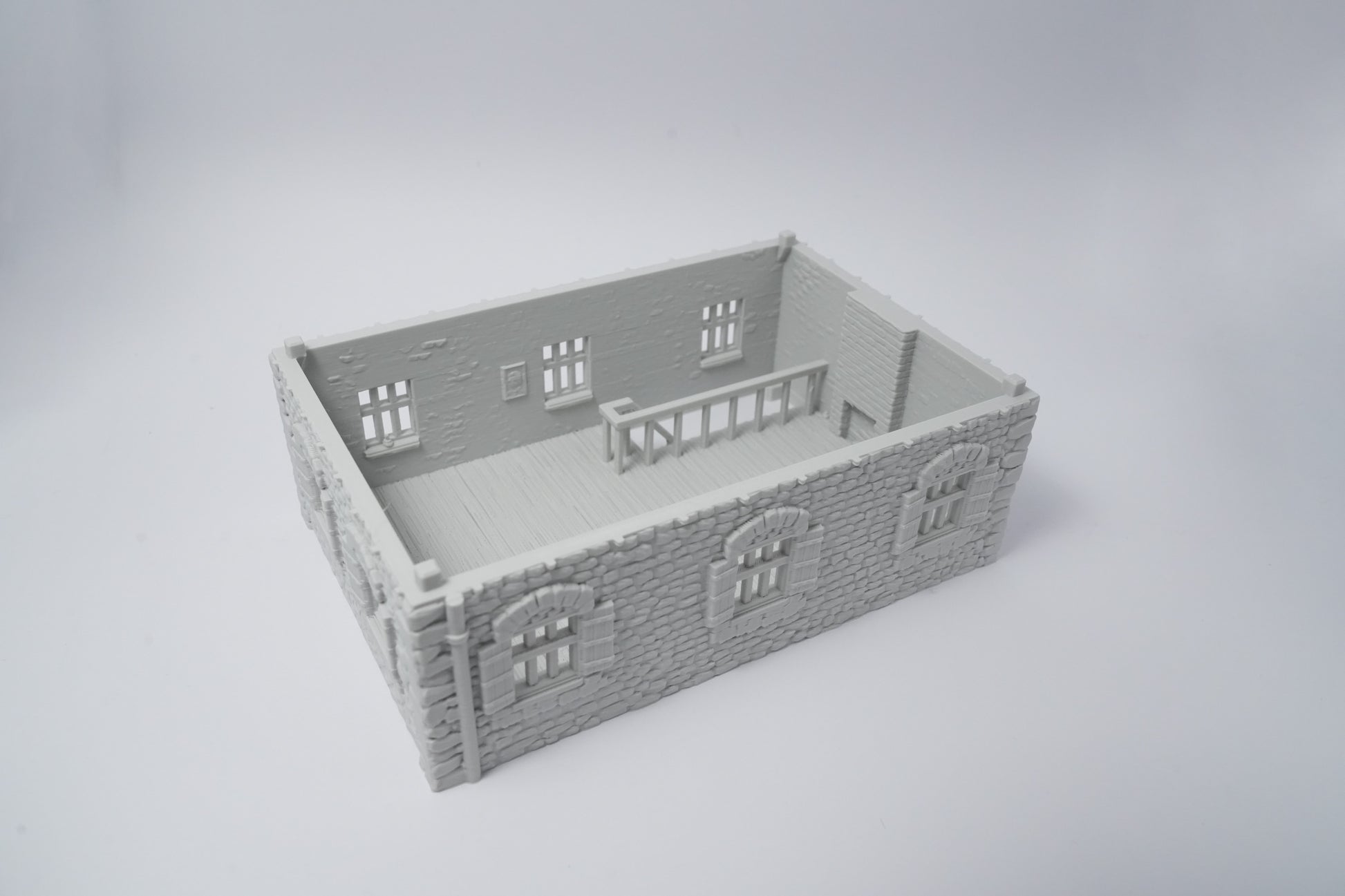 Graues Miniatur-Farmhaus aus Kunststoff mit detaillierten Fenstern und Backsteinmauern, rechteckig.