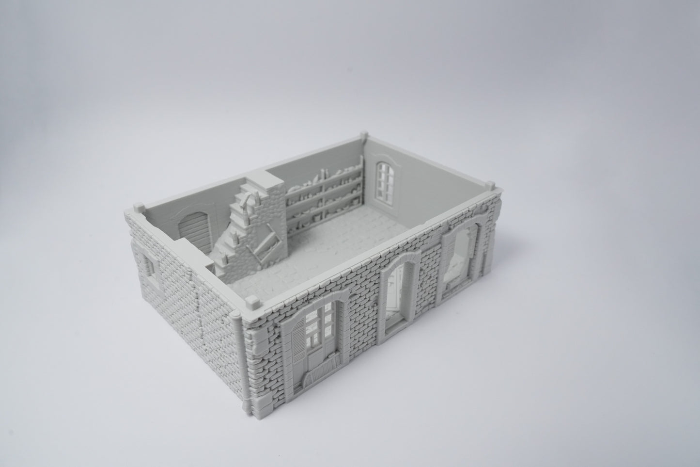 Graues Miniaturmodell einer halb zerstörten französischen Hausruine mit zerfallener Treppe und Fenstern.