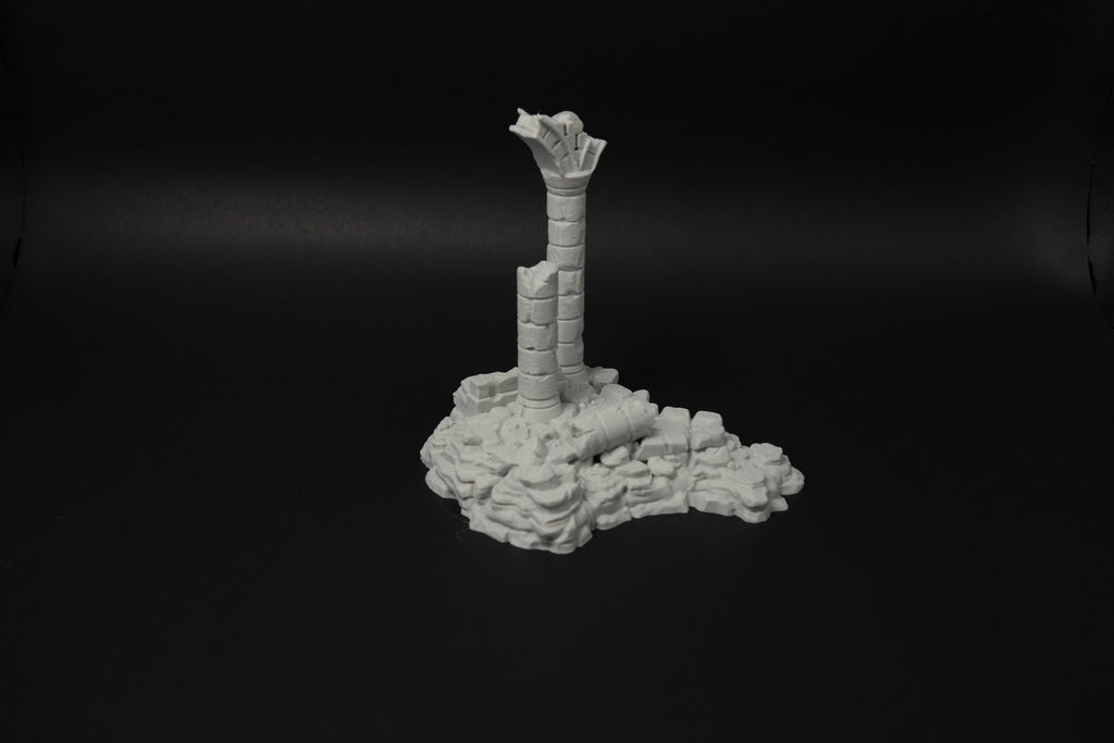 Verwitterte graue Ruinen mit zerbrochener Säule auf unebenem Boden aus Steinen und Trümmern in 28mm Maßstab.