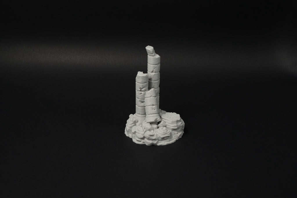 Verwitterte antike Ruine mit zerfallenen Säulen auf rundem Sockel aus Stein in Grau.