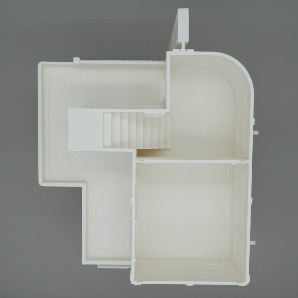 Modell eines großen, weißen Apartmentgebäudes mit Treppenhaus und klar abgegrenzten Räumen von oben betrachtet.