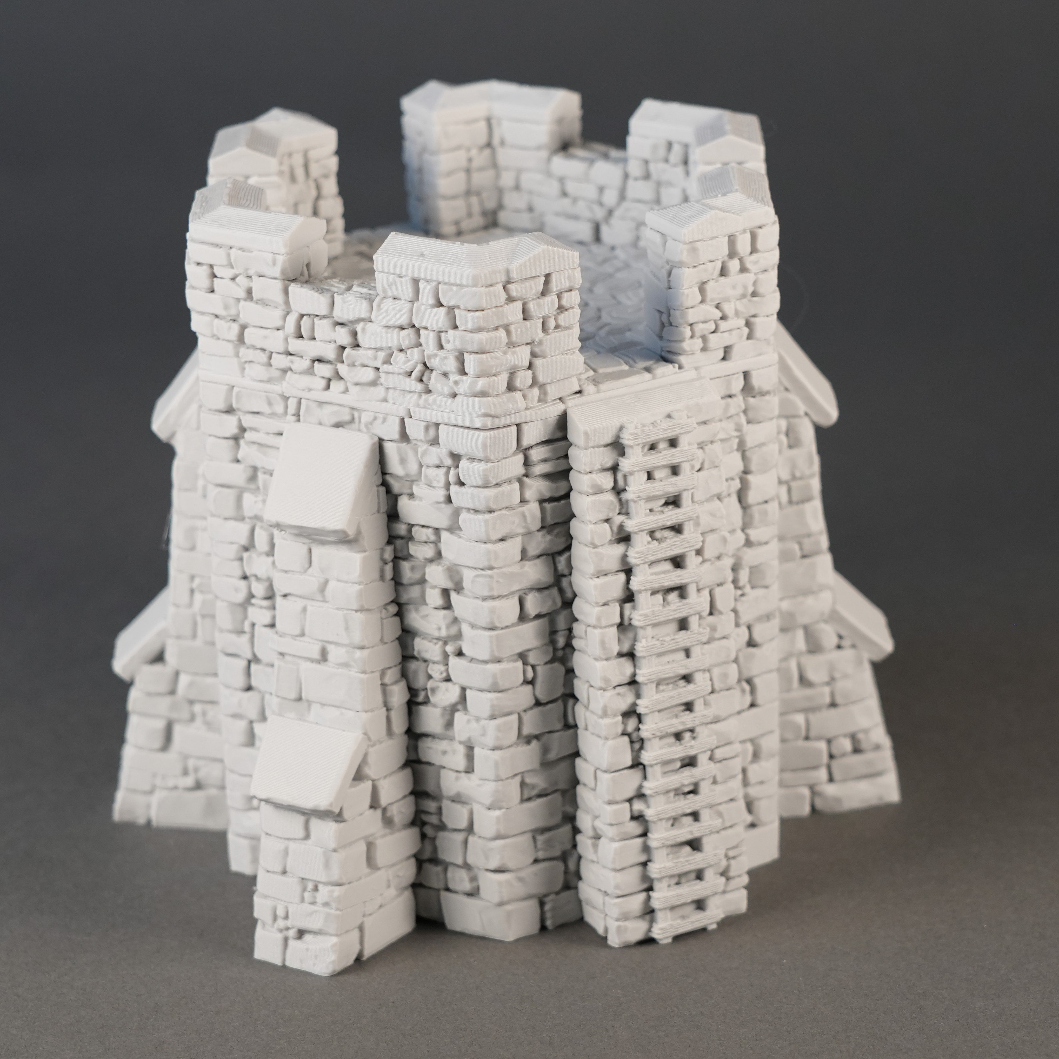 Grauer modulare Burgturm mit Zinnen und detailreicher Steinstruktur.