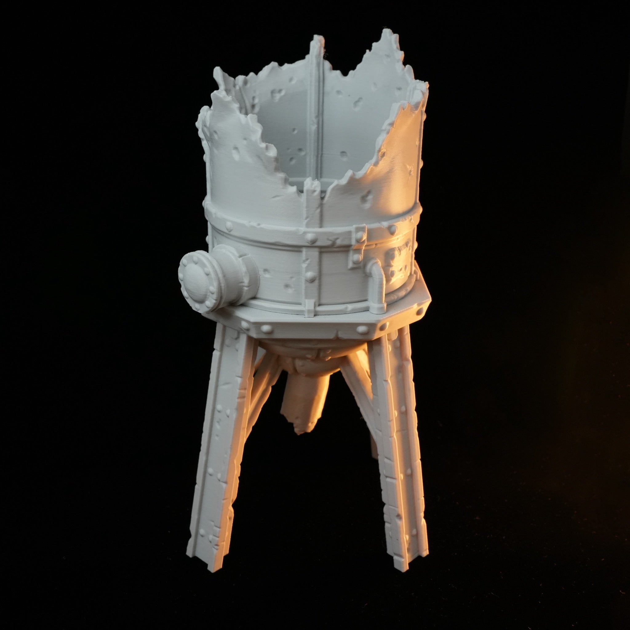 Weißes zerstörtes Hochsilo mit abgebrochenen oberen Kanten auf drei Beinen aus robustem Material.