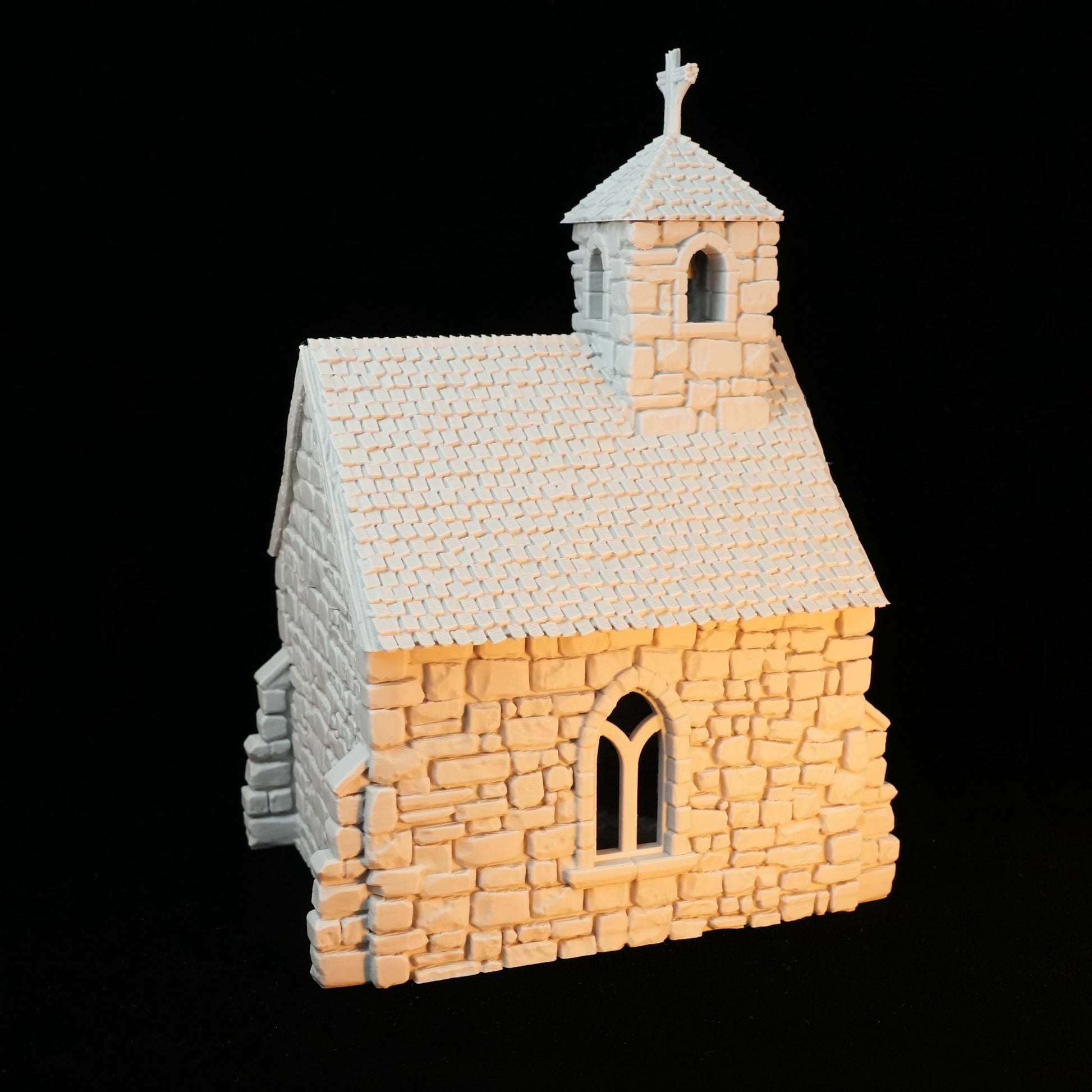 Kleine graue Kapelle aus Stein mit Ziegeldach und Glockenturm mit Kreuz.
