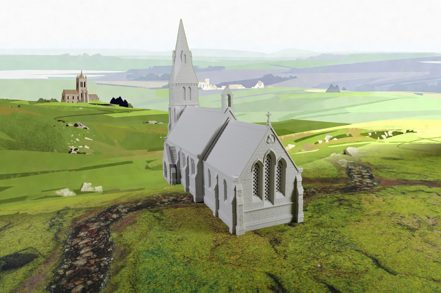 Graues Modell einer mittelalterlichen Kirche mit Turm auf grünem Hügelgelände.