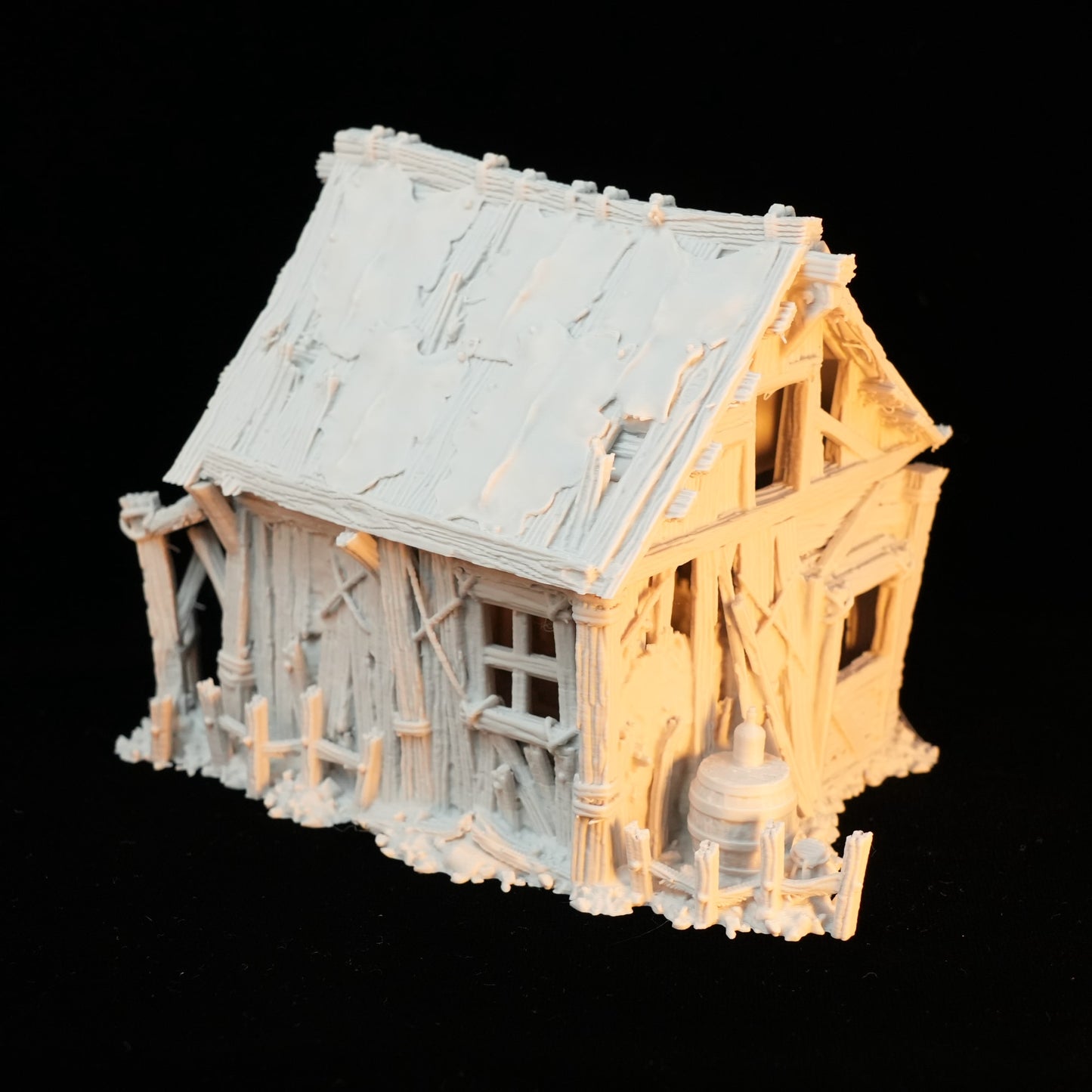 Kleines rustikales Fachwerkhaus aus hellbem Holz mit schiefem Dach und Zaun, Miniaturmodell.