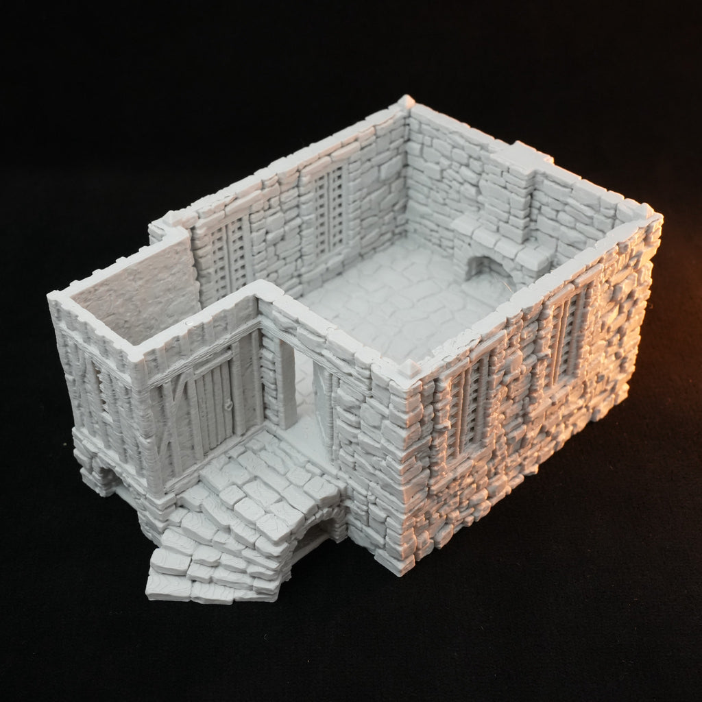 Weißes Modell eines steinernen Bauernhauses mit offener Rückseite und detaillierten Mauern.