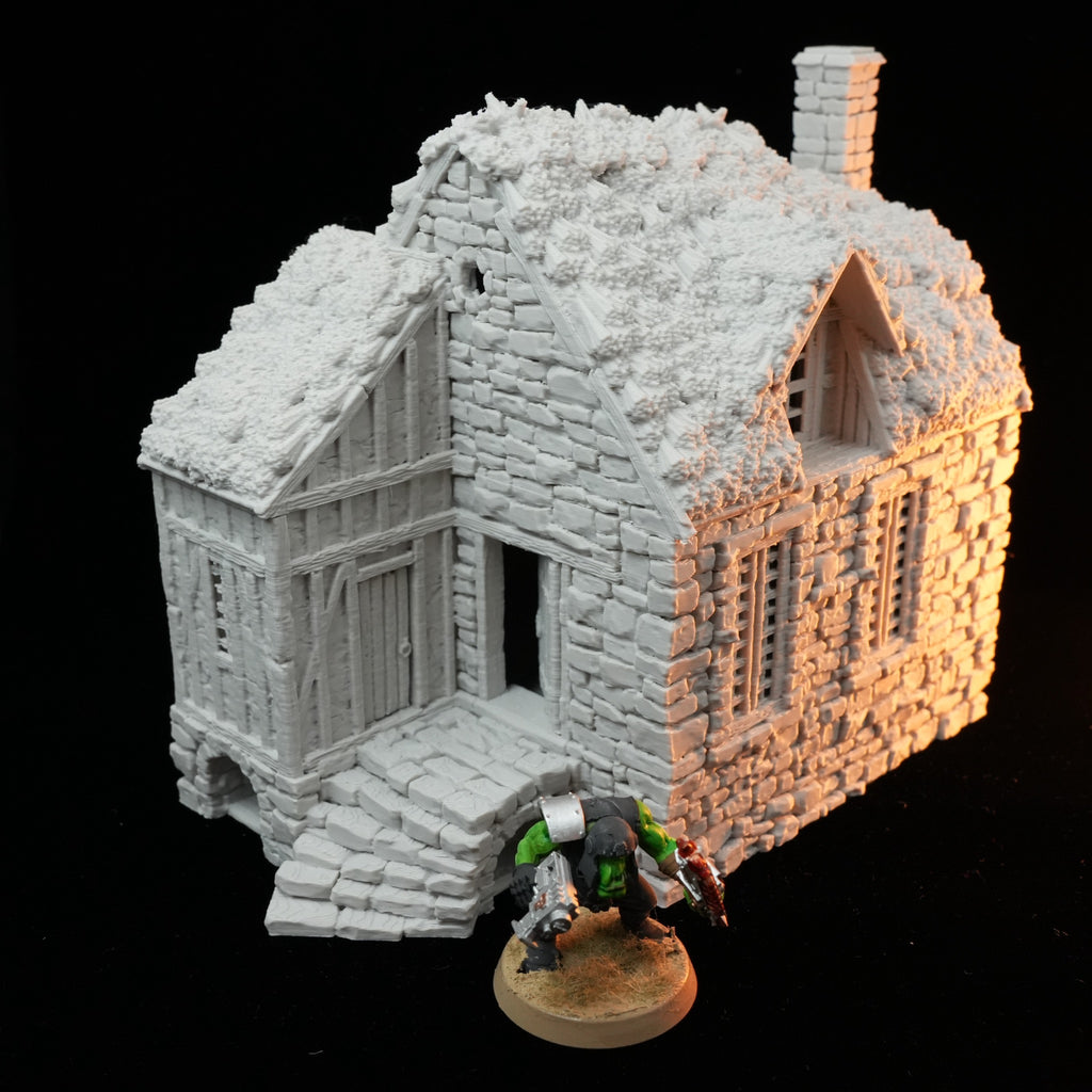 Weißes Miniaturmodell eines Bauernhauses mit Fachwerk, Schornstein und Stufen vor der Tür.