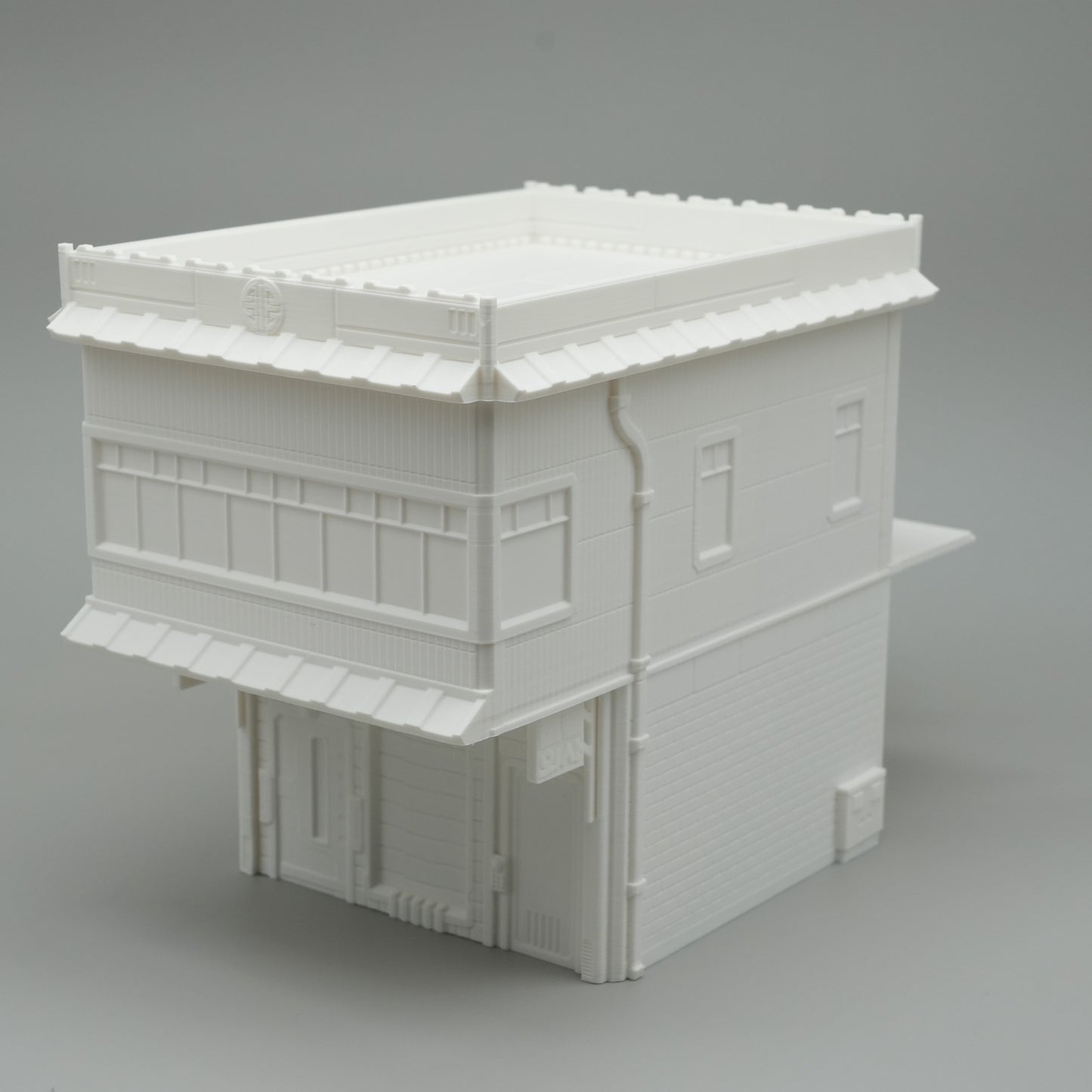 Weißes, zweistöckiges Modellgebäude mit Flachdach und Fensterfronten im minimalistischen Stil.