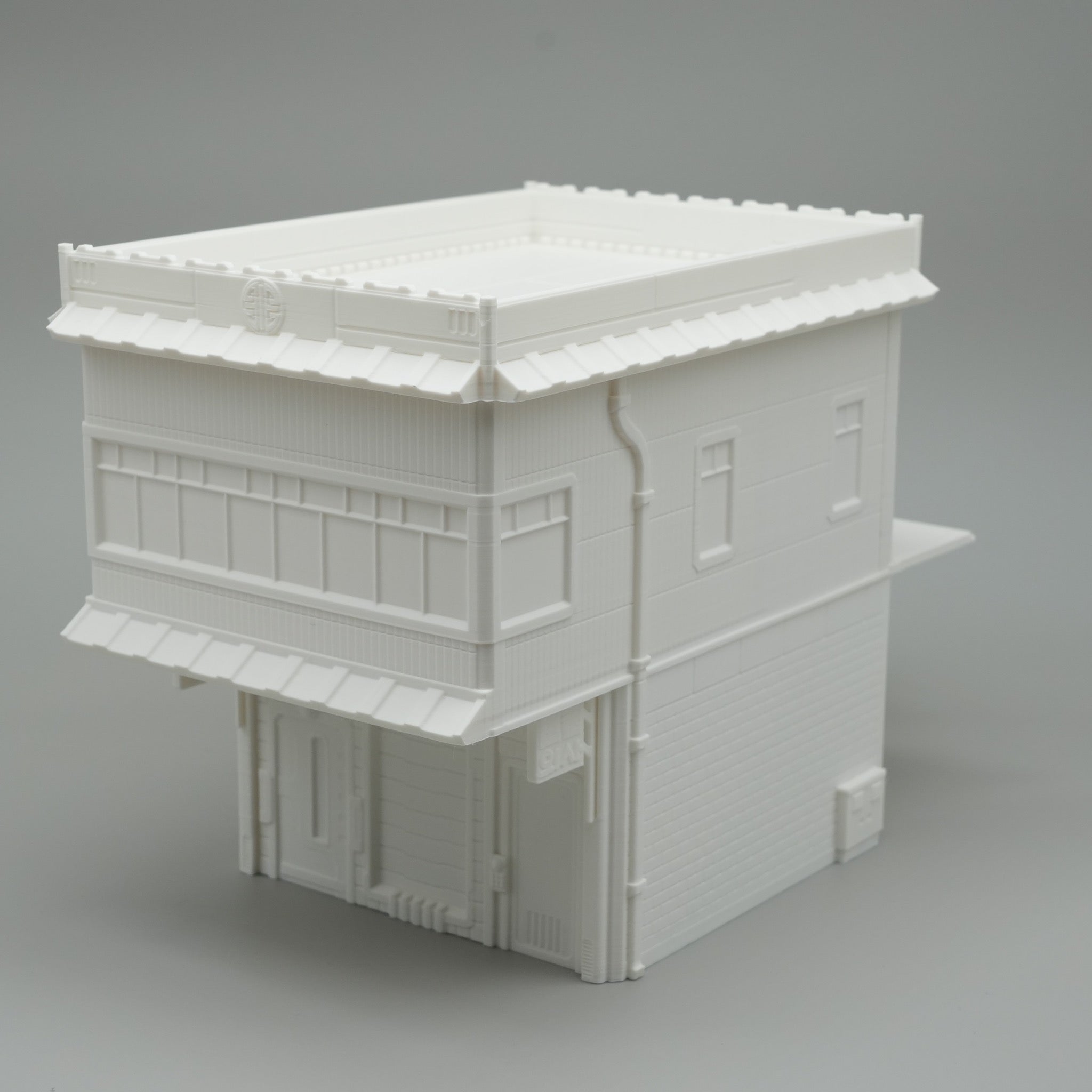 Weißes, zweistöckiges Modellgebäude mit Flachdach und Fensterfronten im minimalistischen Stil.