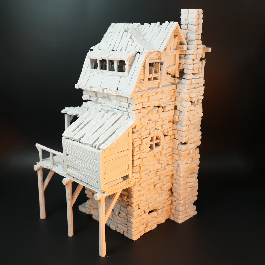 Weißes, detailreiches Miniatur-Torhaus aus Stein mit Holzsteg und Schornstein, beschädigtes Dach.