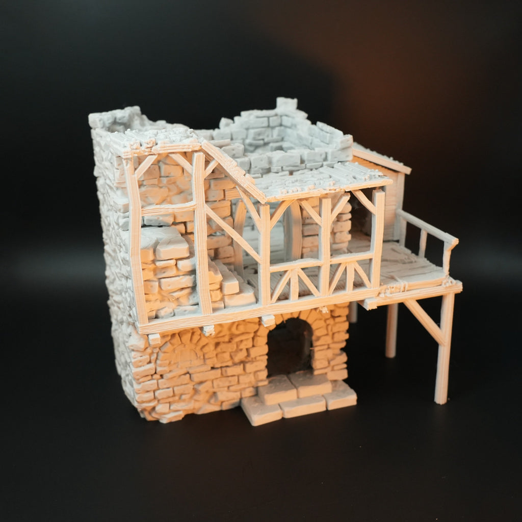 Zerfallenes Torhaus aus Stein und Holz, halbes Obergeschoss mit Holzgeländer und Steintreppe.