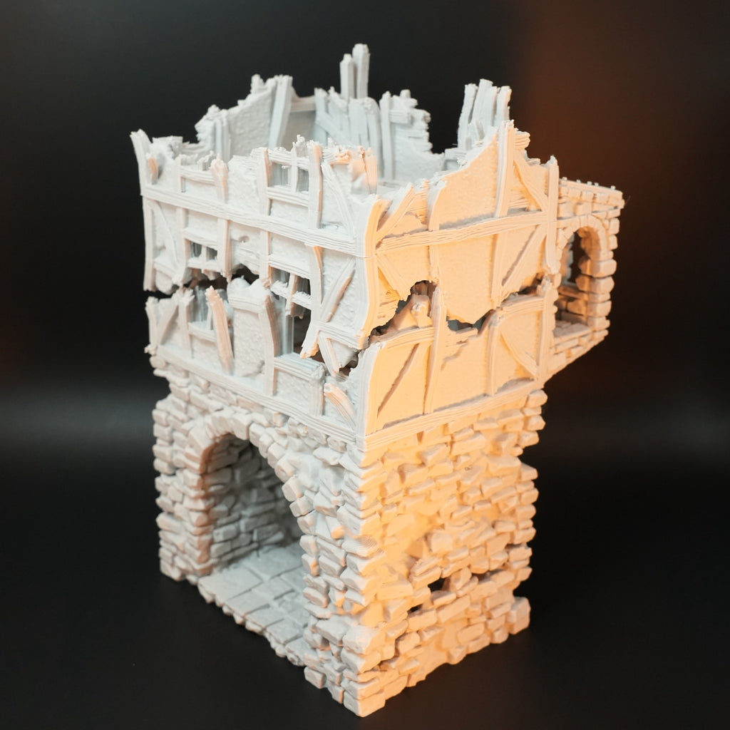 Zerfallenes Torhaus aus Stein mit halb zerstörten Holzelementen und großem Torbogen.