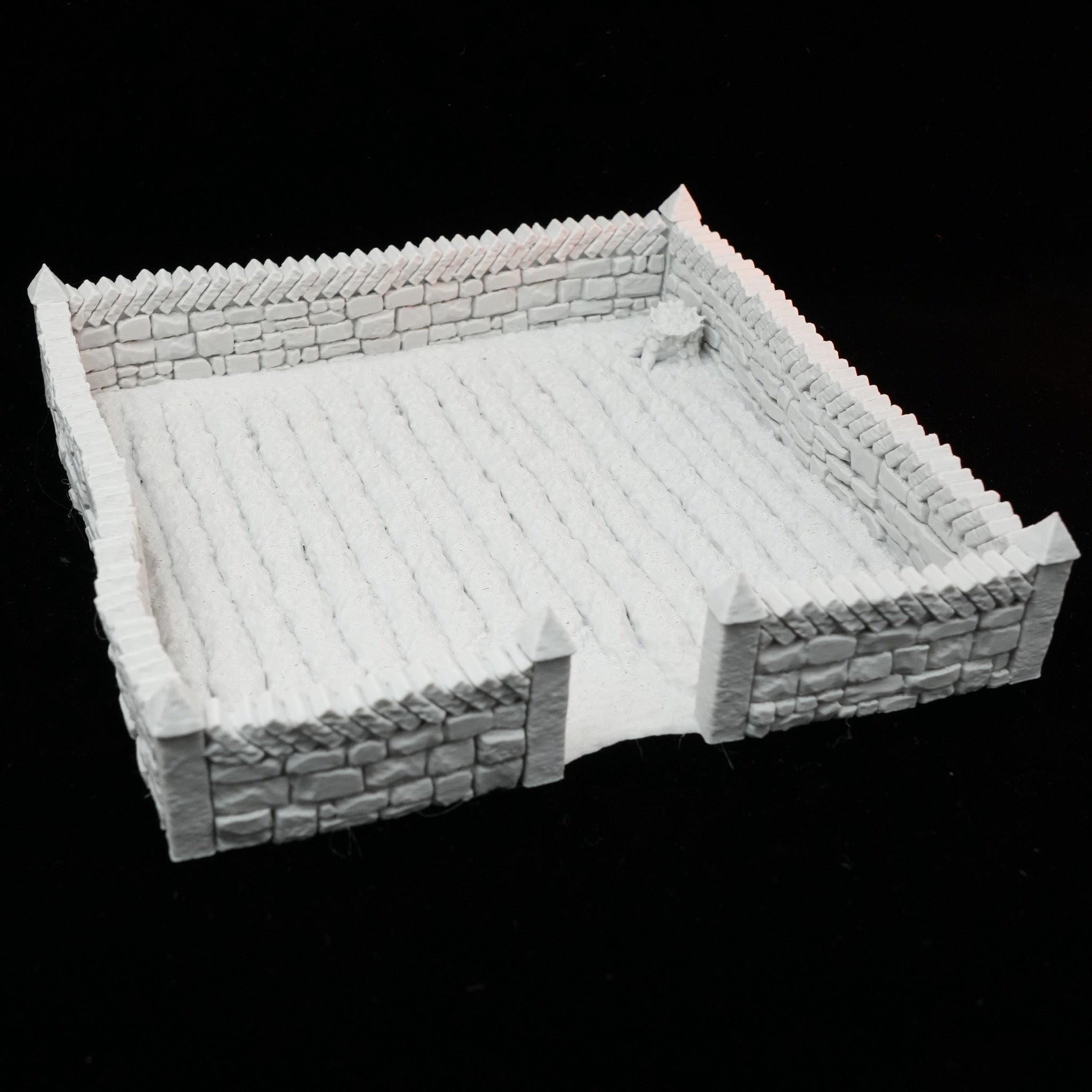 Unbemaltes weißes Modell eines Ackerfeldes mit eingefasstem Steinzaun und Reihenstruktur.