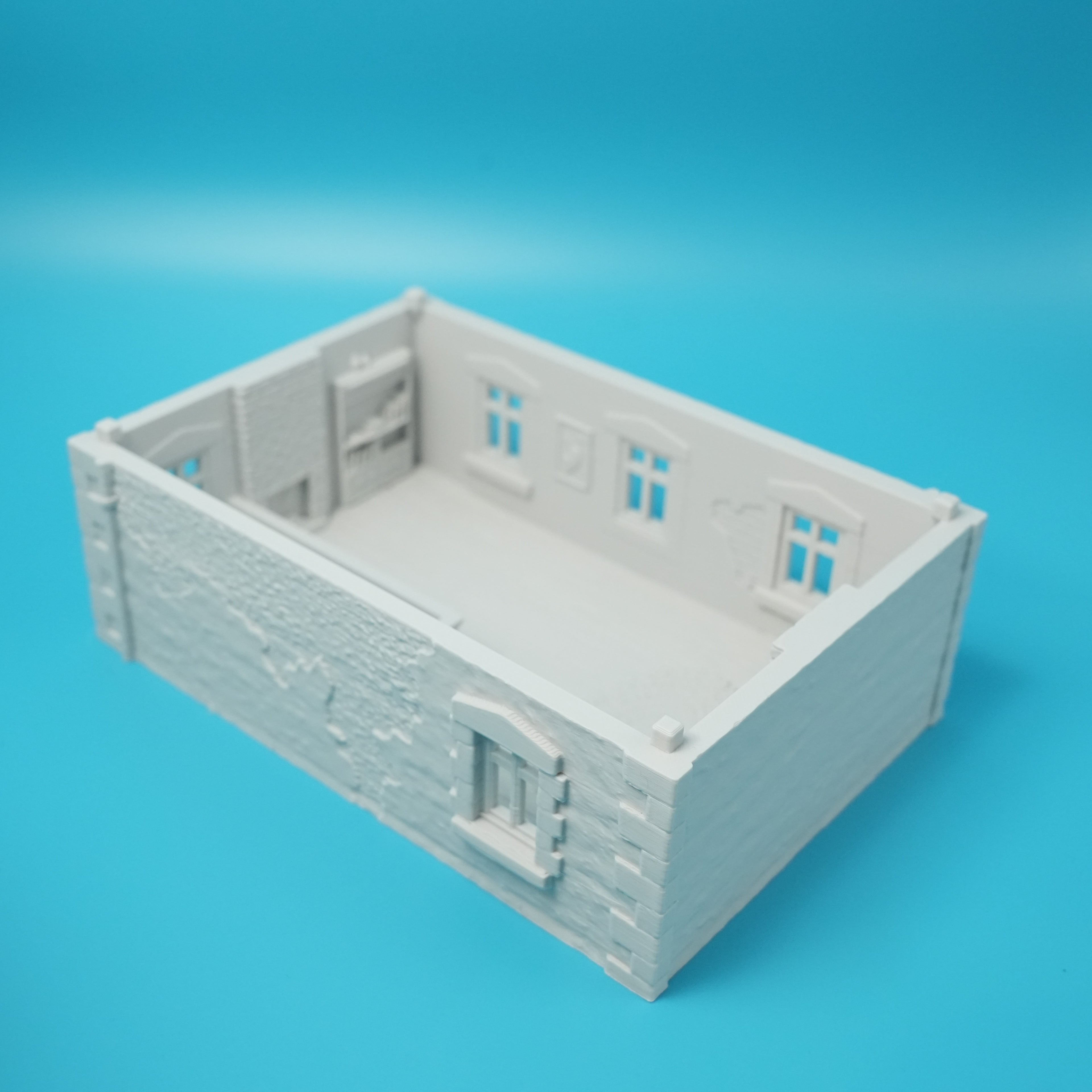 Weißes französisches Stadthaus-Modell mit Fenster- und Türdetails, rustikale Wandstruktur.