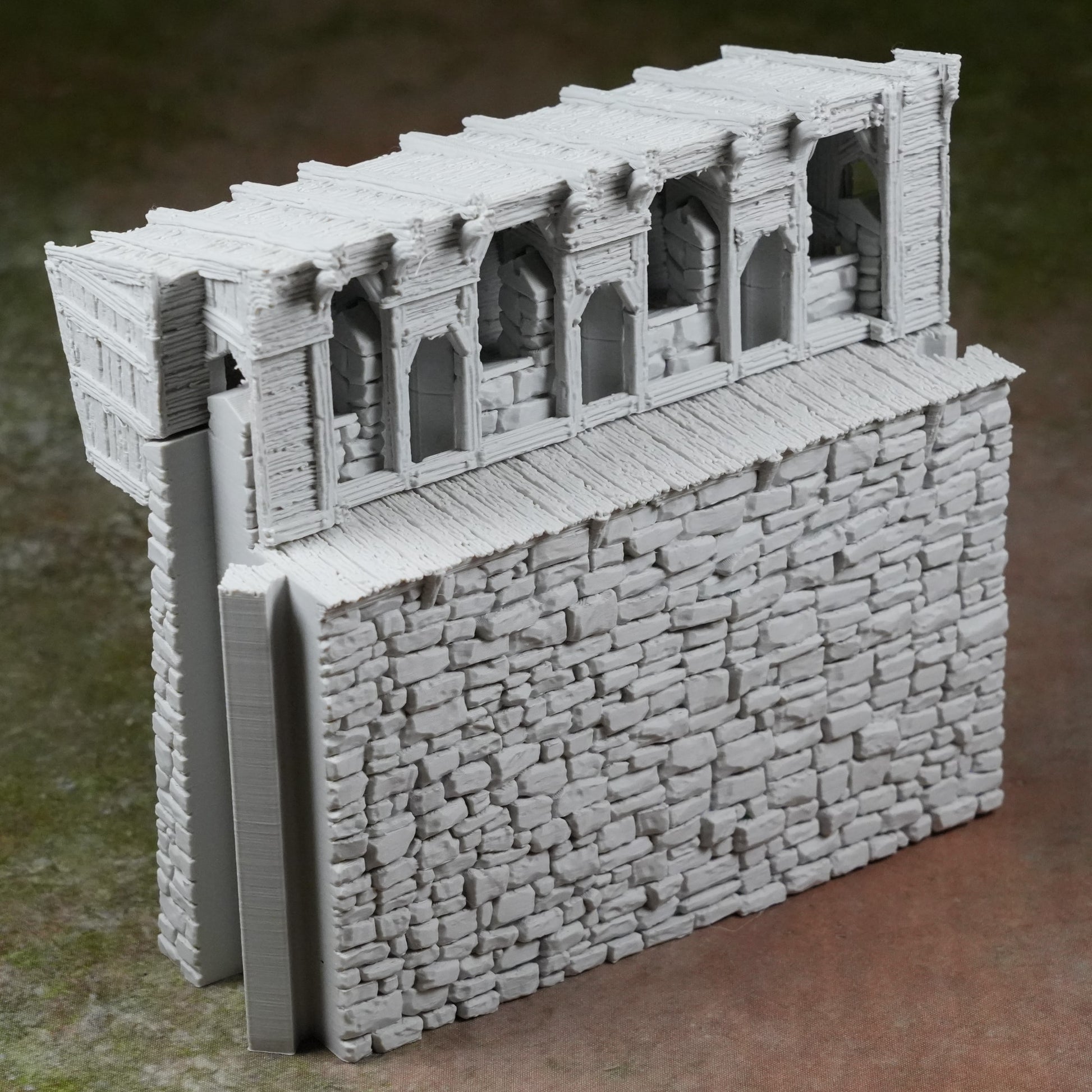 Graue modulare Burgmauer mit Zinnen und Fenstern aus steiniger Struktur, detailreich gestaltet.