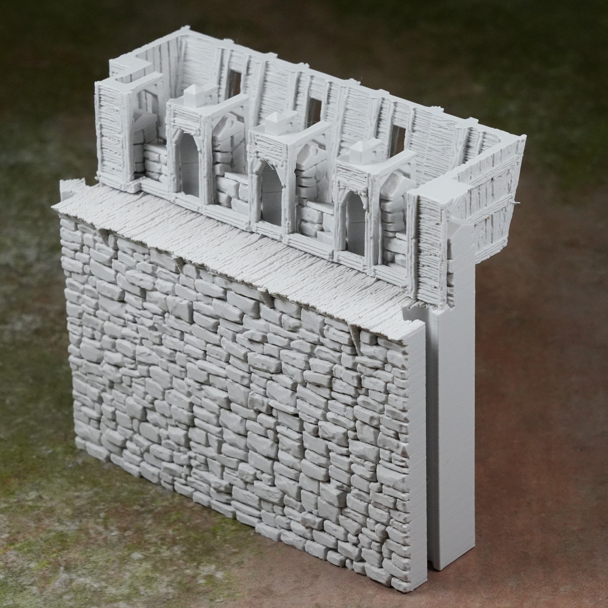 Grauer Burgturm mit strukturierter Mauer und detailliertem Battlement-Maueraufsatz aus Stein.