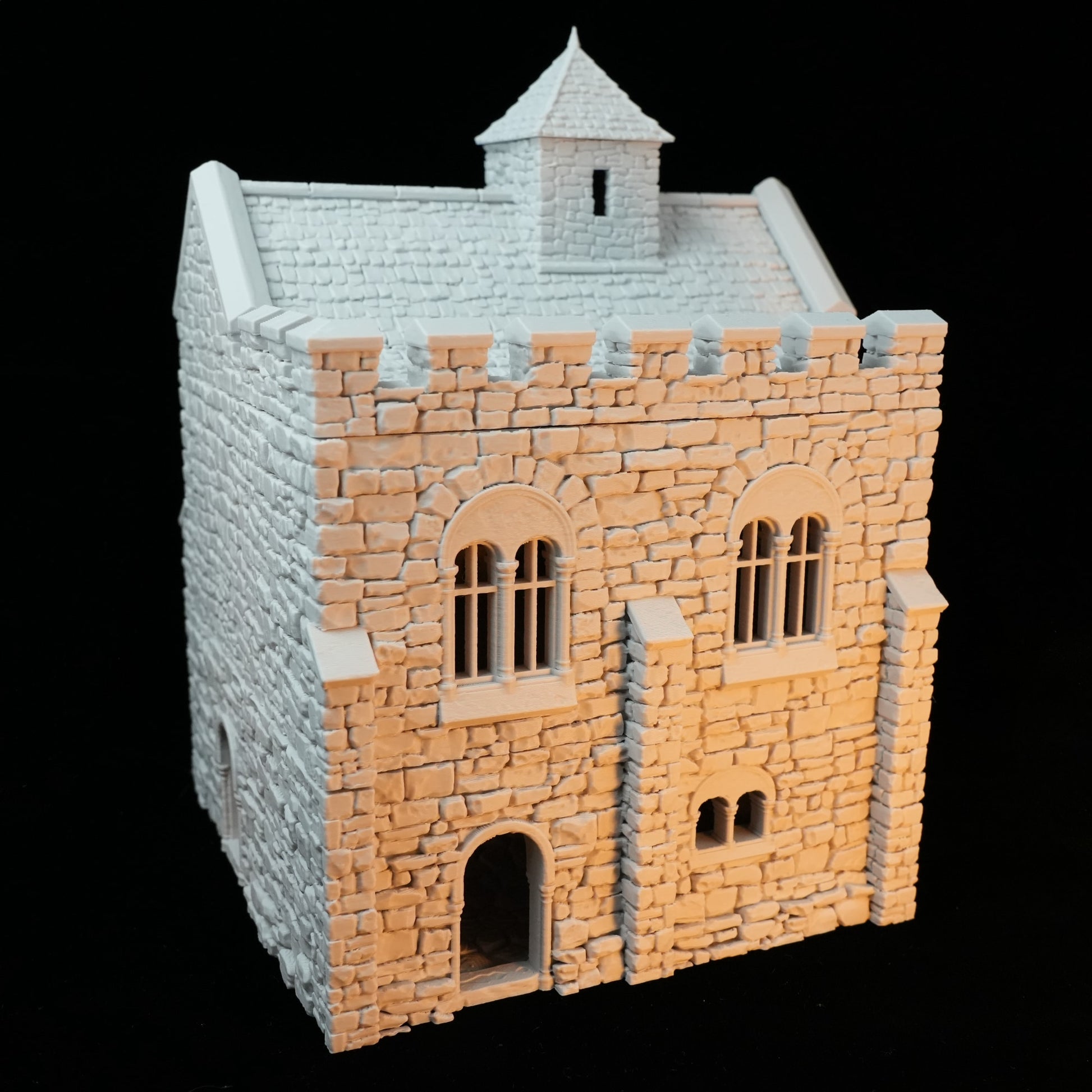 Hellgrauer Steinbau mit Zinnenmauer, kleinen Fenstern und einem Dachaufbau in Miniaturmaßstab.