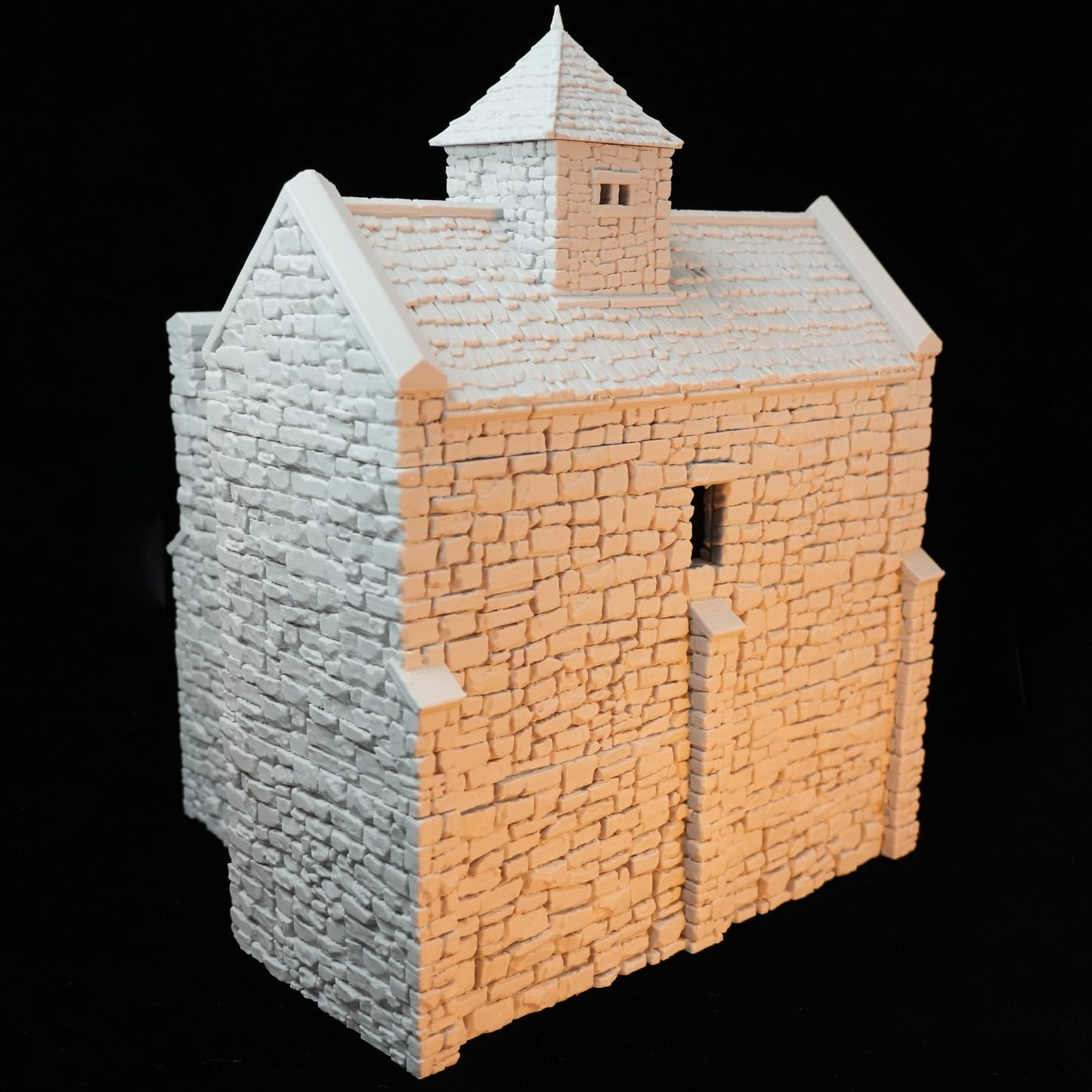 Miniatur-Modell eines normannischen Steinturms mit schiefergrauem Mauerwerk und spitzem Dach aus hellem Material.