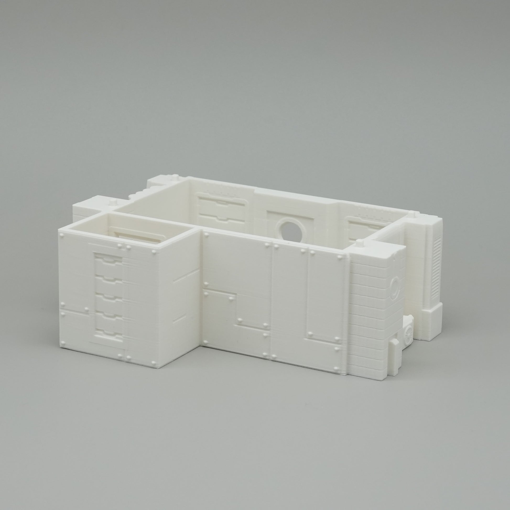 Weißes, minimalistisches Modell eines Waschraums aus Kunststoff mit Schubladen und Wanddetails.