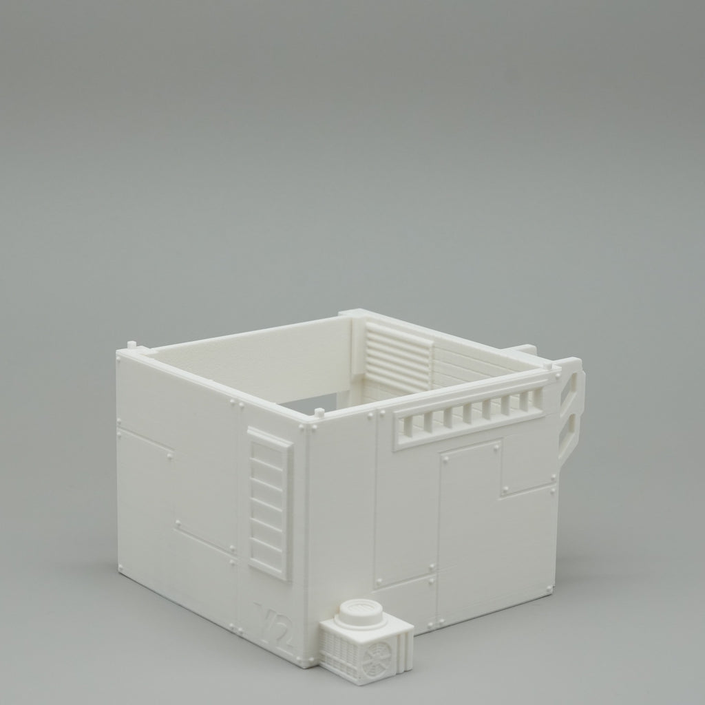 Weißes Modellhaus mit offener Dachterrasse und kleinem Rundtisch am Eingang.