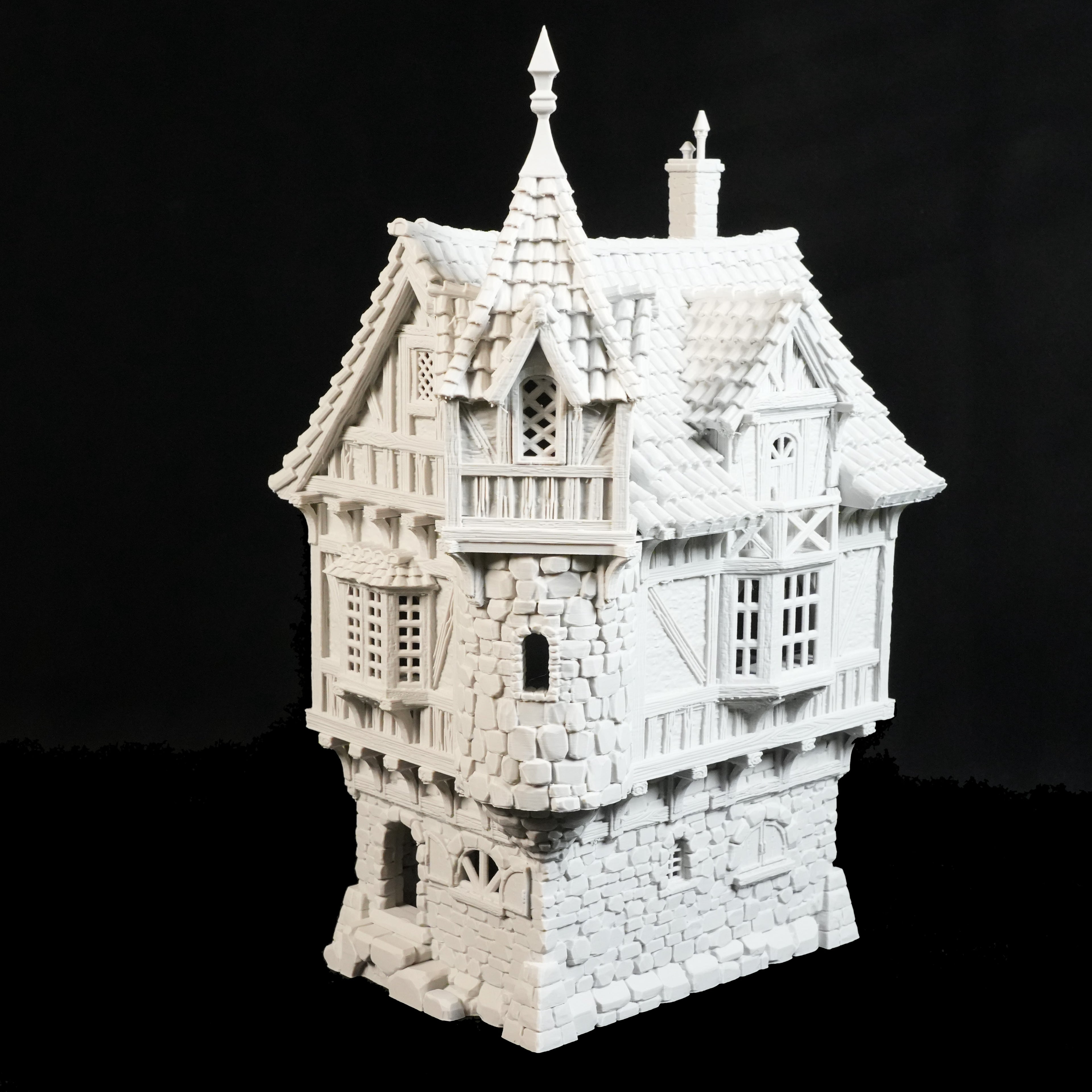 Das Governors Mansion Herrenhaus von Nebelstein Prints ist ein detailliertes weißes 3D-gedrucktes Modell mit steilem Dach, Steinsockel, hölzernem Oberteil und verzierten Fenstern - ideal für Fantasy-Städte oder Tabletop-Gelände - auf schwarzem Hintergrund.