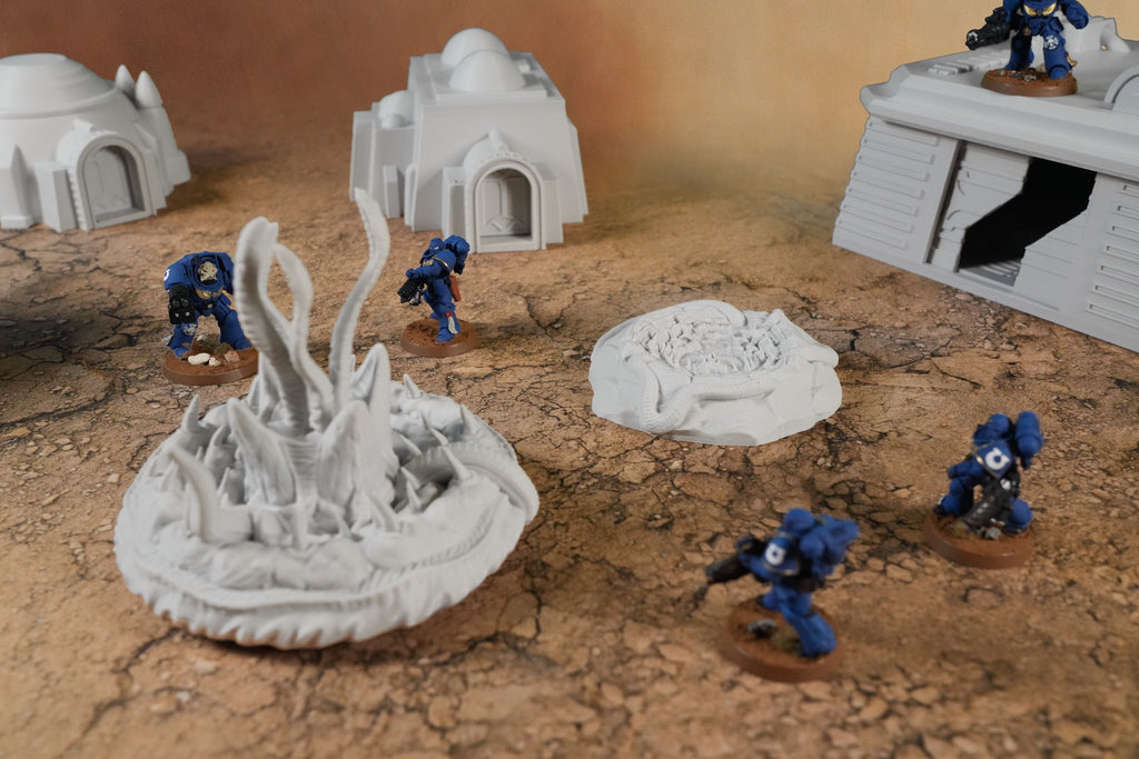 Graue Miniatur-Diorama-Wüstenmodule mit Kuppelhäusern, Sandwurmhügel und Soldatenfiguren auf zerklüftetem Wüstensand.