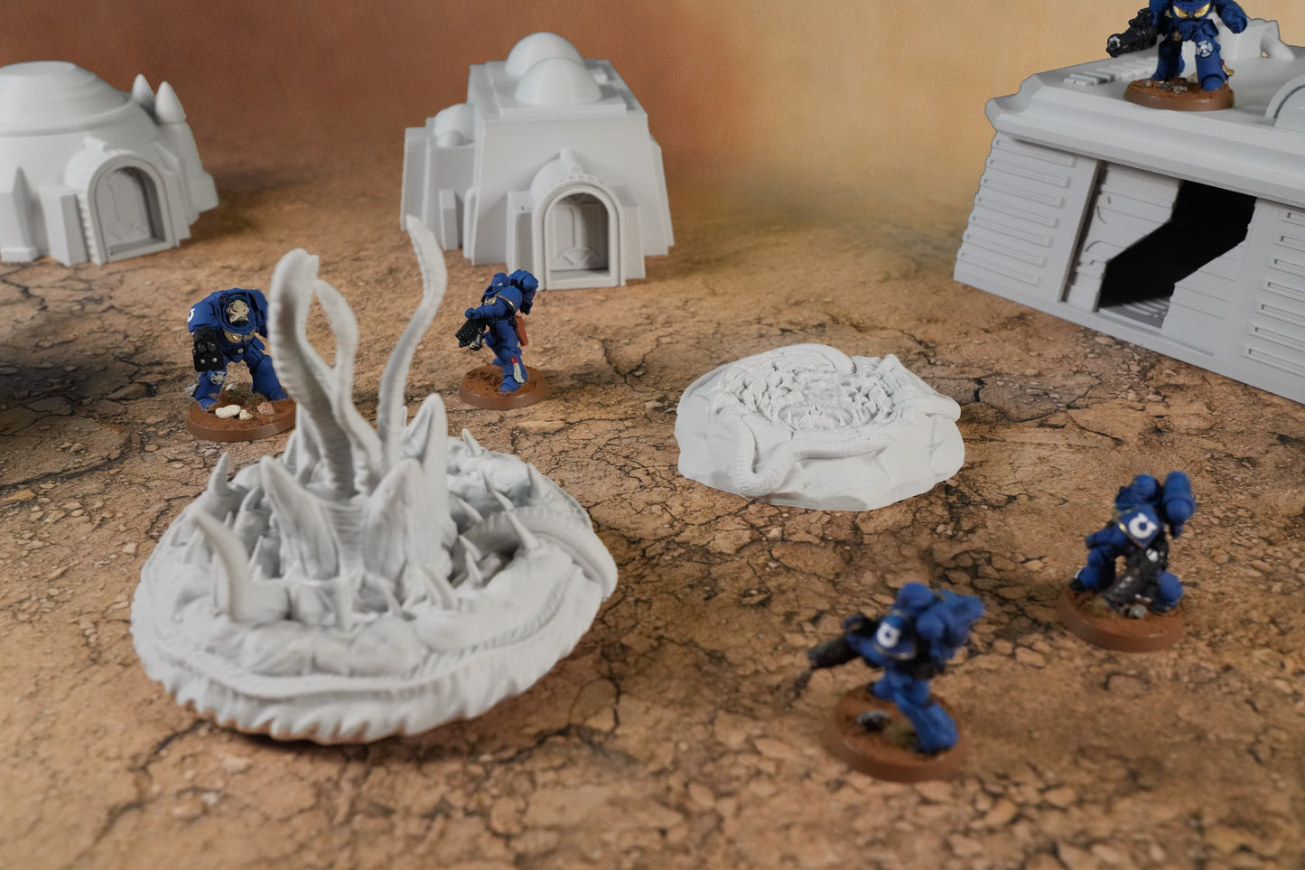 Graue Miniatur-Diorama-Wüstenmodule mit Kuppelhäusern, Sandwurmhügel und Soldatenfiguren auf zerklüftetem Wüstensand.
