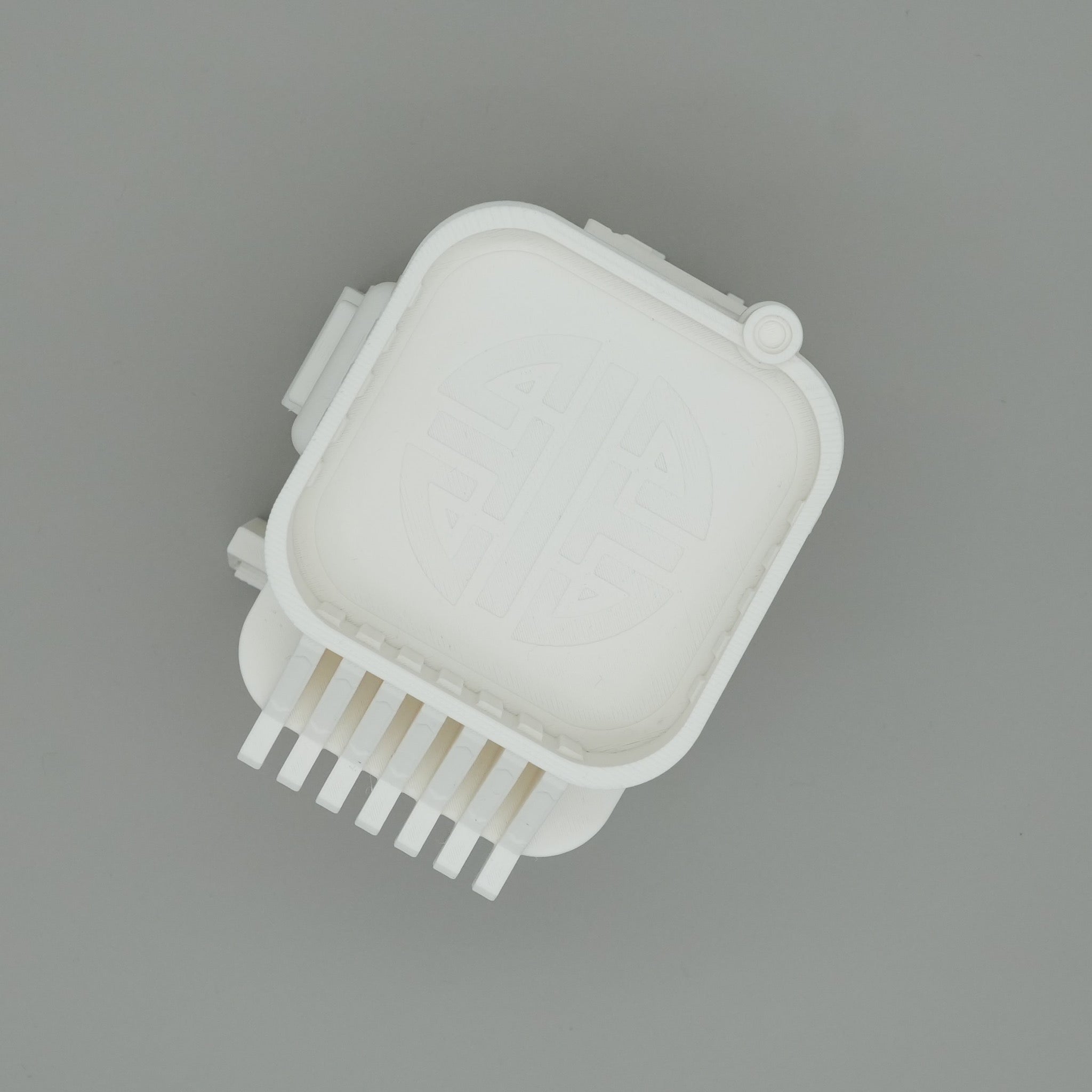 Kleiner weißer quadratischer Miniatur-Kiosk mit abgerundeten Ecken und Gitterrückseite.