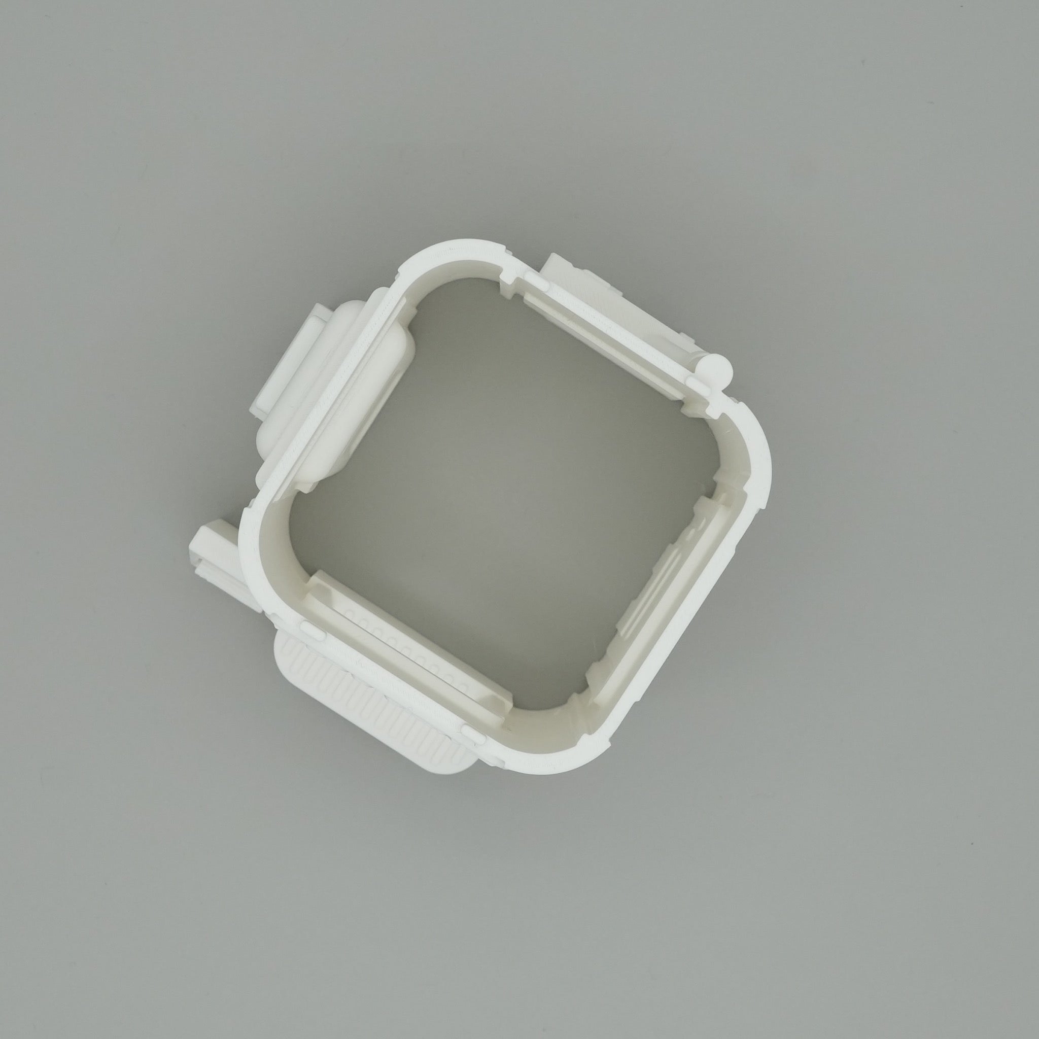 Weißes rechteckiges Kunststoffgestell mit abgerundeten Ecken und vier Schienen an den Seiten.