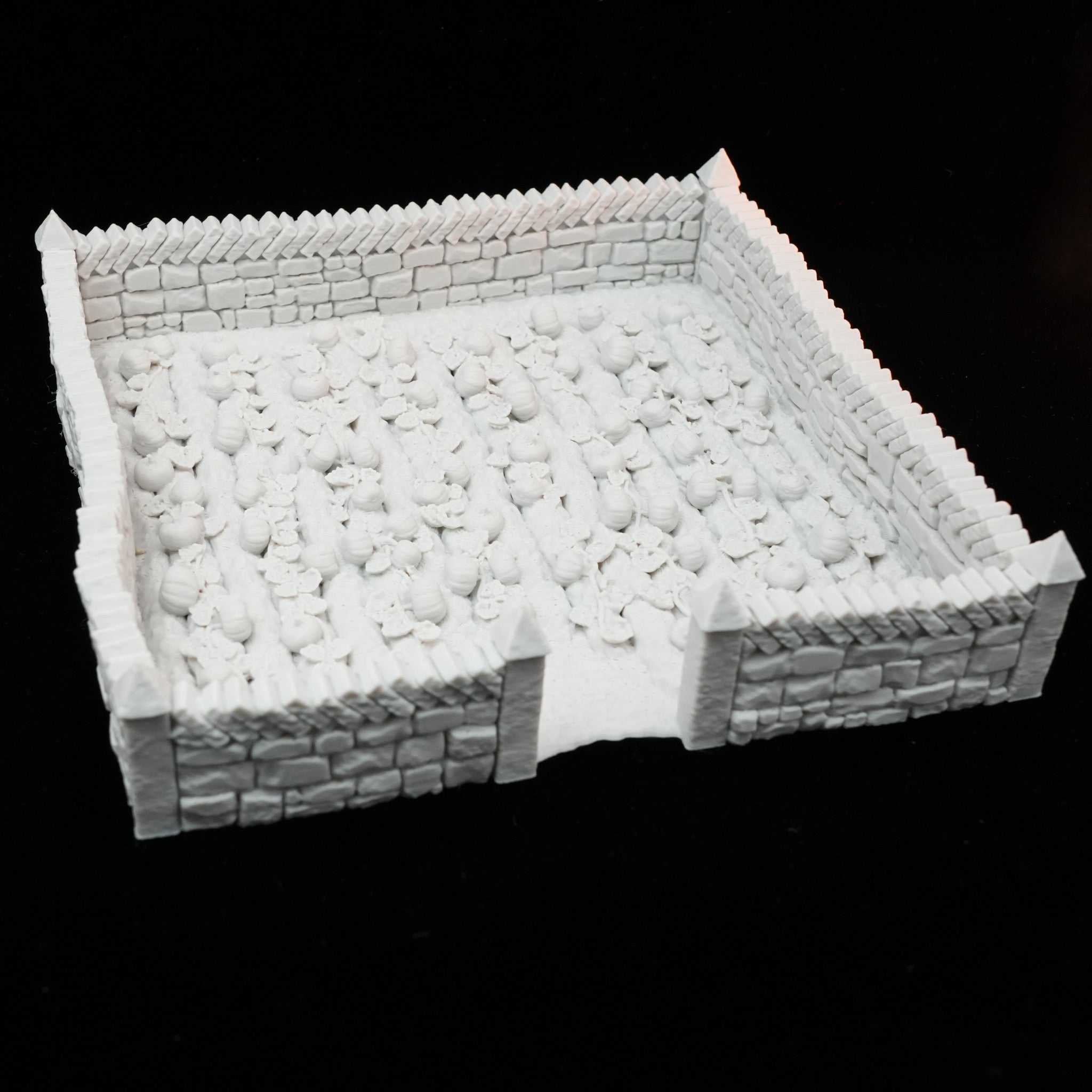 Weiß lackiertes, detailreiches Modell eines ummauerten Ackerfelds mit Reihen gepflügter Erde auf schwarzem Hintergrund.