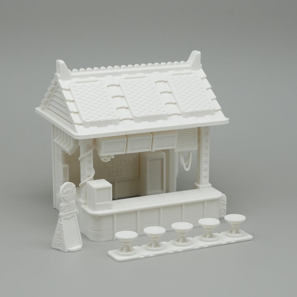 Weißer Miniatur-Ramen-Stand mit traditionellem Dach und separater Theke mit Hockern aus Kunststoff.