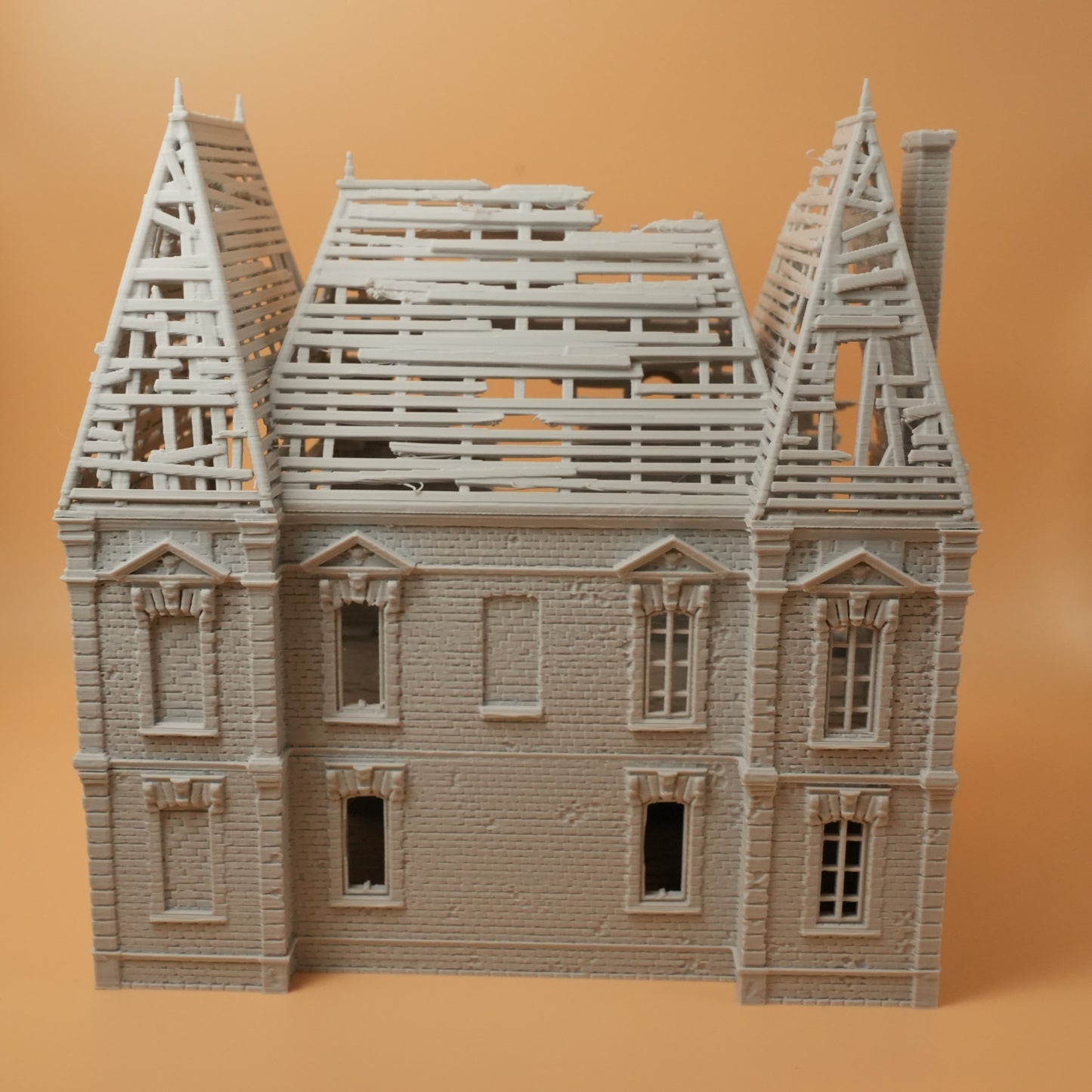 Zerstörtes Herrenhaus mit fehlendem Dach und beschädigten Fenstern, detaillierte Ruine in hellem Material.