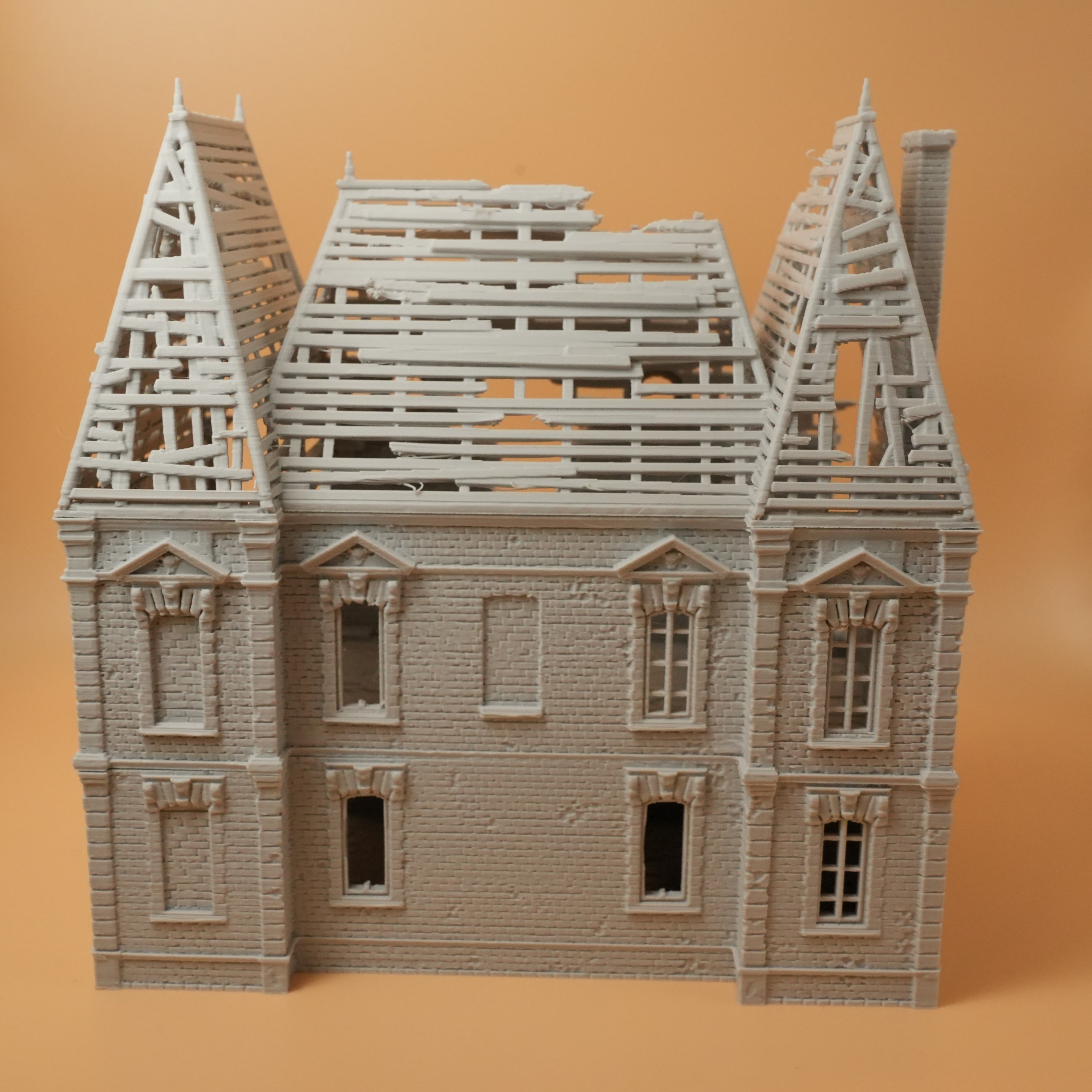 Zerstörtes Herrenhaus mit fehlendem Dach und beschädigten Fenstern, detaillierte Ruine in hellem Material.