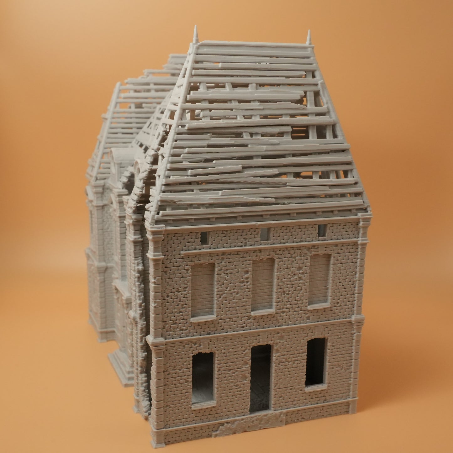 Modell eines zerstörten Herrenhauses mit teilweise eingestürztem Dach und leerstehenden Fenstern in 28mm Größe.