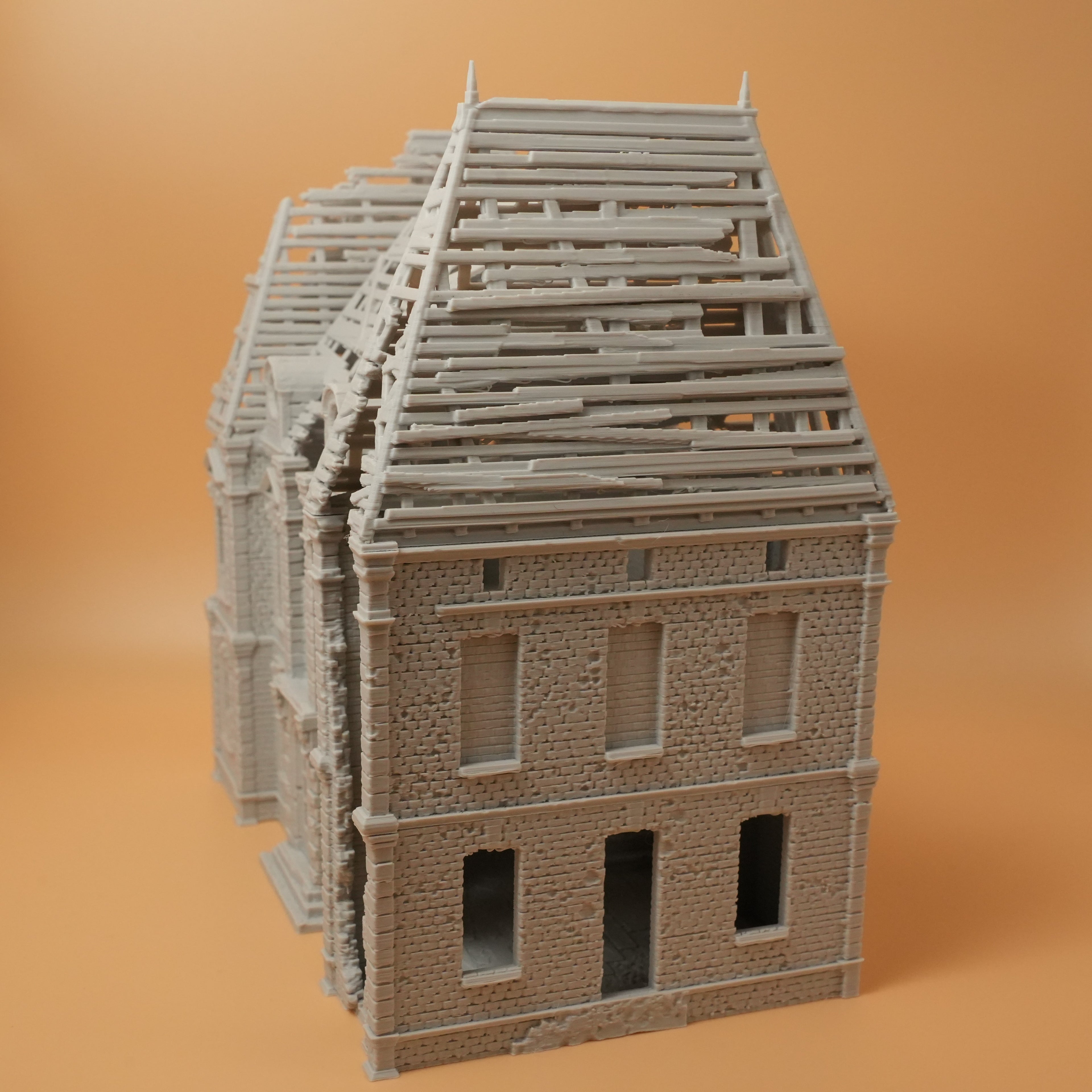 Modell eines zerstörten Herrenhauses mit teilweise eingestürztem Dach und leerstehenden Fenstern in 28mm Größe.