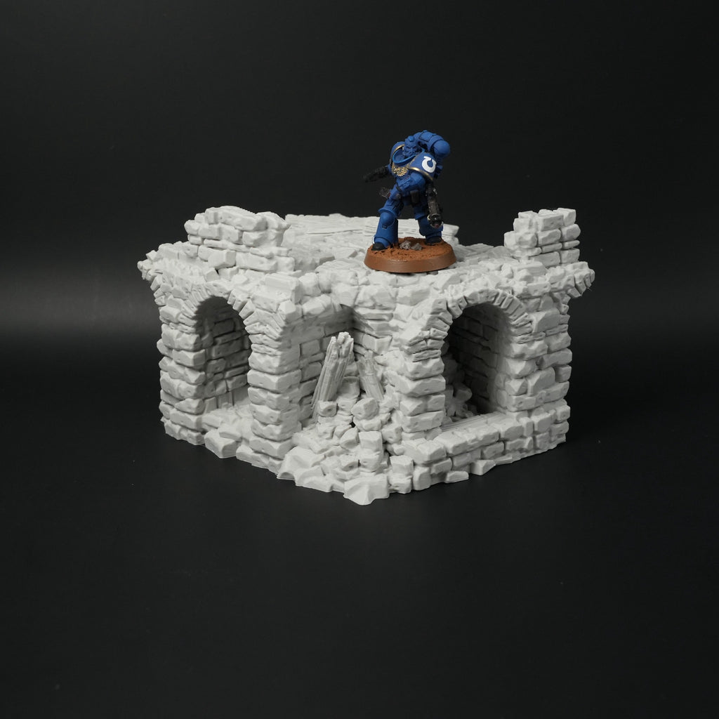 Zerfallene graue Steinbrücke mit drei Torbögen und zertrümmerten Mauerteilen, Miniaturmaßstab.