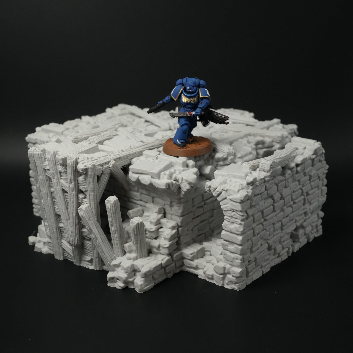 Zerfallene graue Steinbrücke mit Holzstreben und figurinem blauen Miniaturspieler auf bröckelnder Oberfläche.